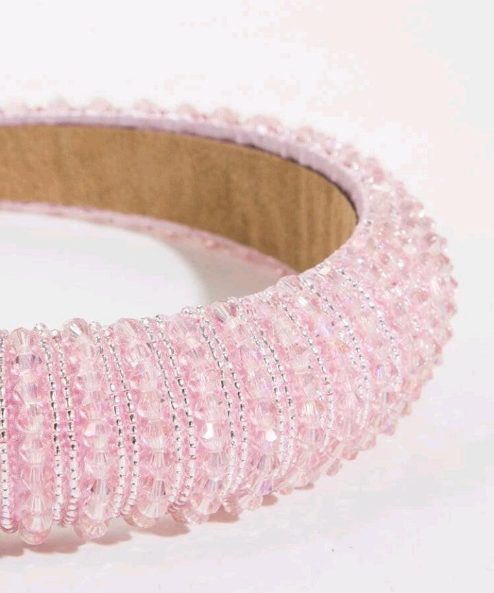 An opulent and elegant pink crystal decorative headband, designed with luxury style in mind. The headband features intricate crystal embellishments in various shades of pink, creating a stunning and glamorous accessory for any occasion.