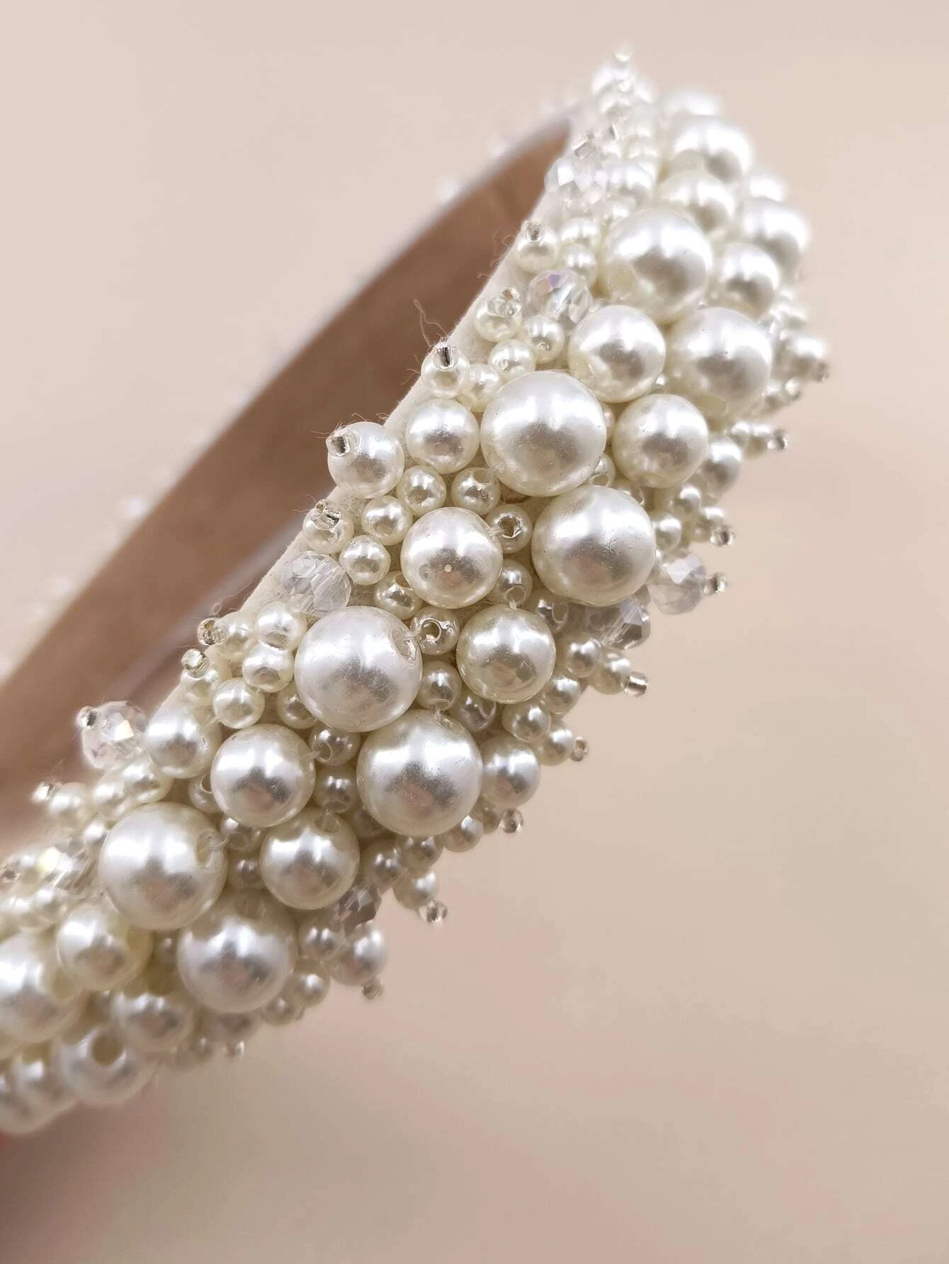 Headband adorned with faux pearls, offering a blend of sophistication and fashion for various looks.
