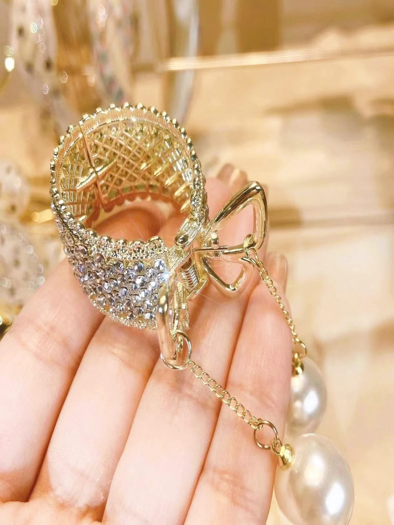 Hair claw adorned with rhinestones and faux pearls, offering a chic and stylish way to secure your hair.