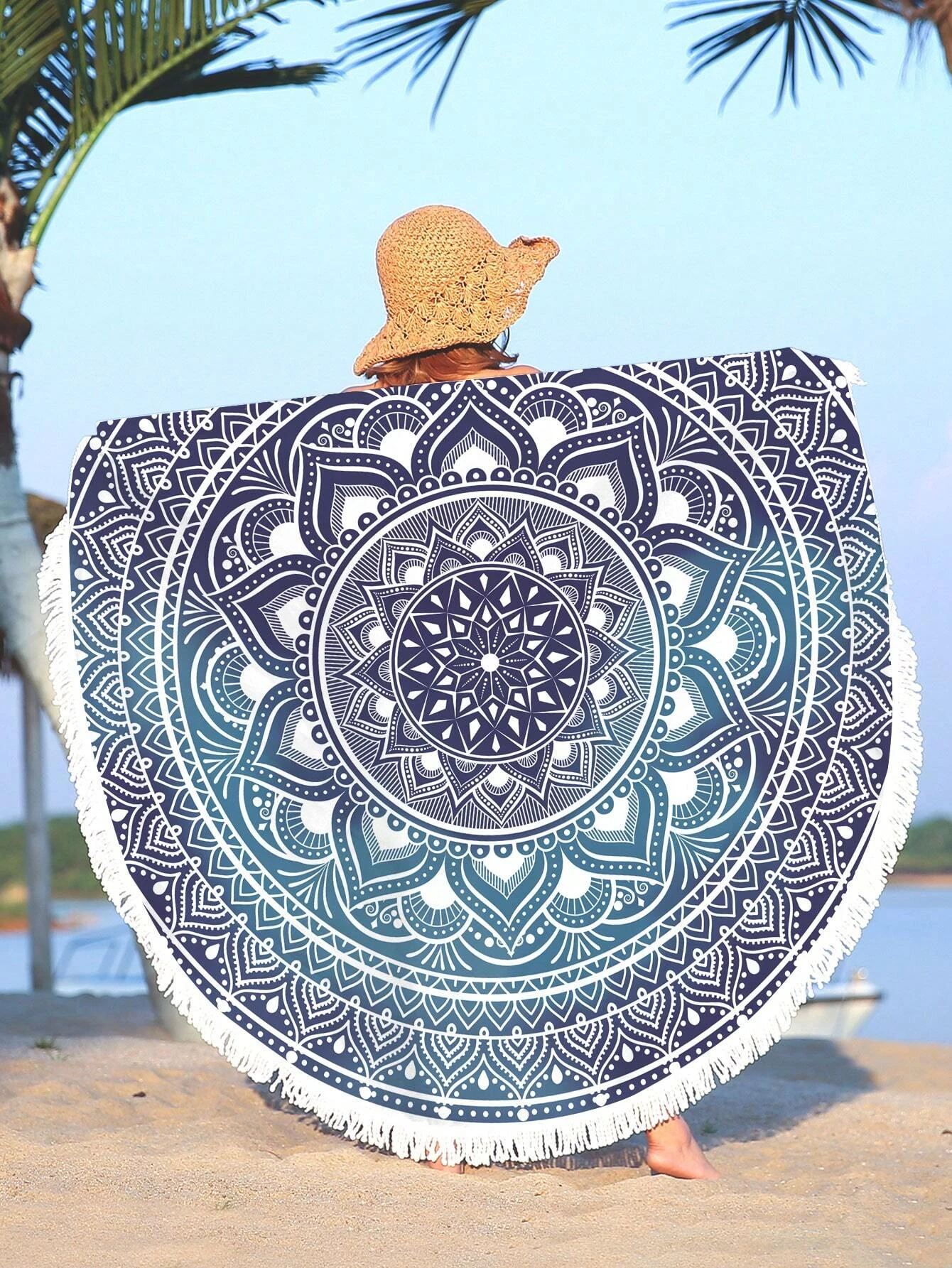 A boho beach towel with a blue ombre mandala print and fringe trim. The towel features a gradient of blue colors in a mandala pattern, with fringe trim along the edges. This towel is stylish and versatile, suitable for beach outings or outdoor relaxation. The blue ombre design and fringe trim add a touch of bohemian flair to the towel.