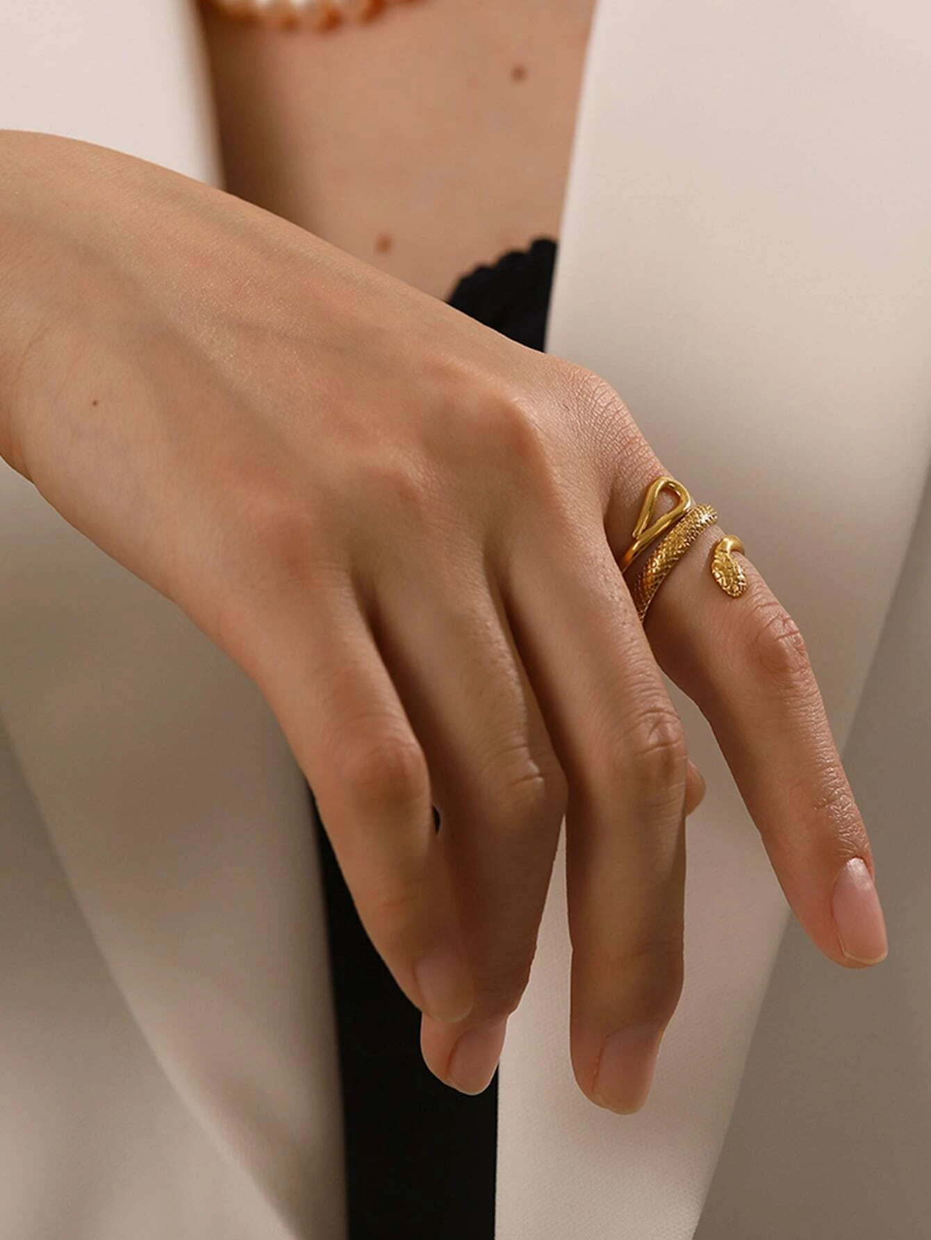 A modern stainless steel wrap ring with a snake design. The ring features an open-ended wrap style that showcases a snake motif at the ends. The snake design is intricately detailed, creating a stylish and edgy look. Crafted from stainless steel, this ring is a versatile and fashionable accessory that adds a touch of intrigue and sophistication to any outfit.