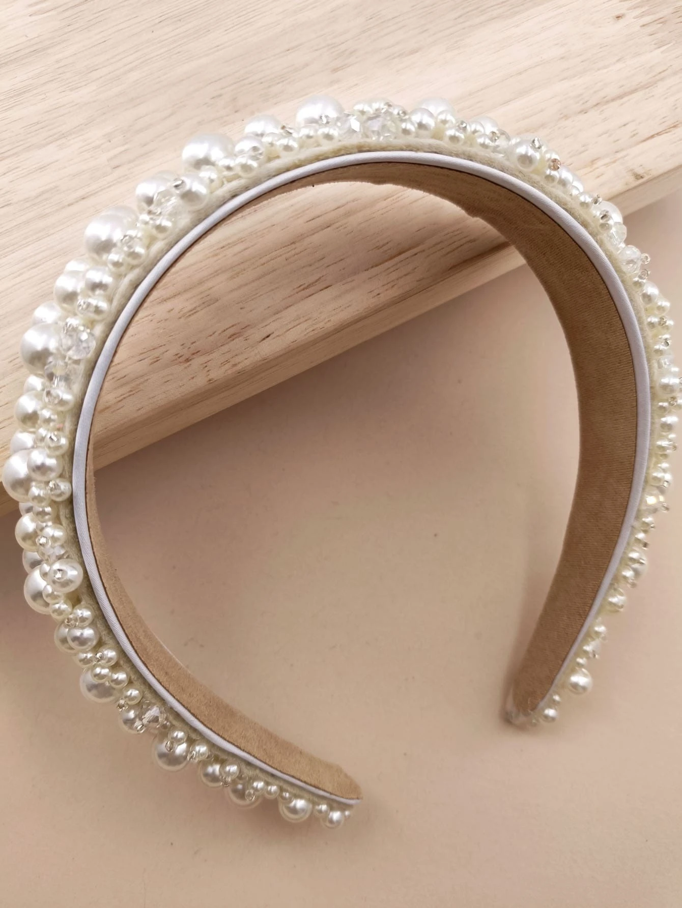 Headband adorned with faux pearls, offering a blend of sophistication and fashion for various looks.
