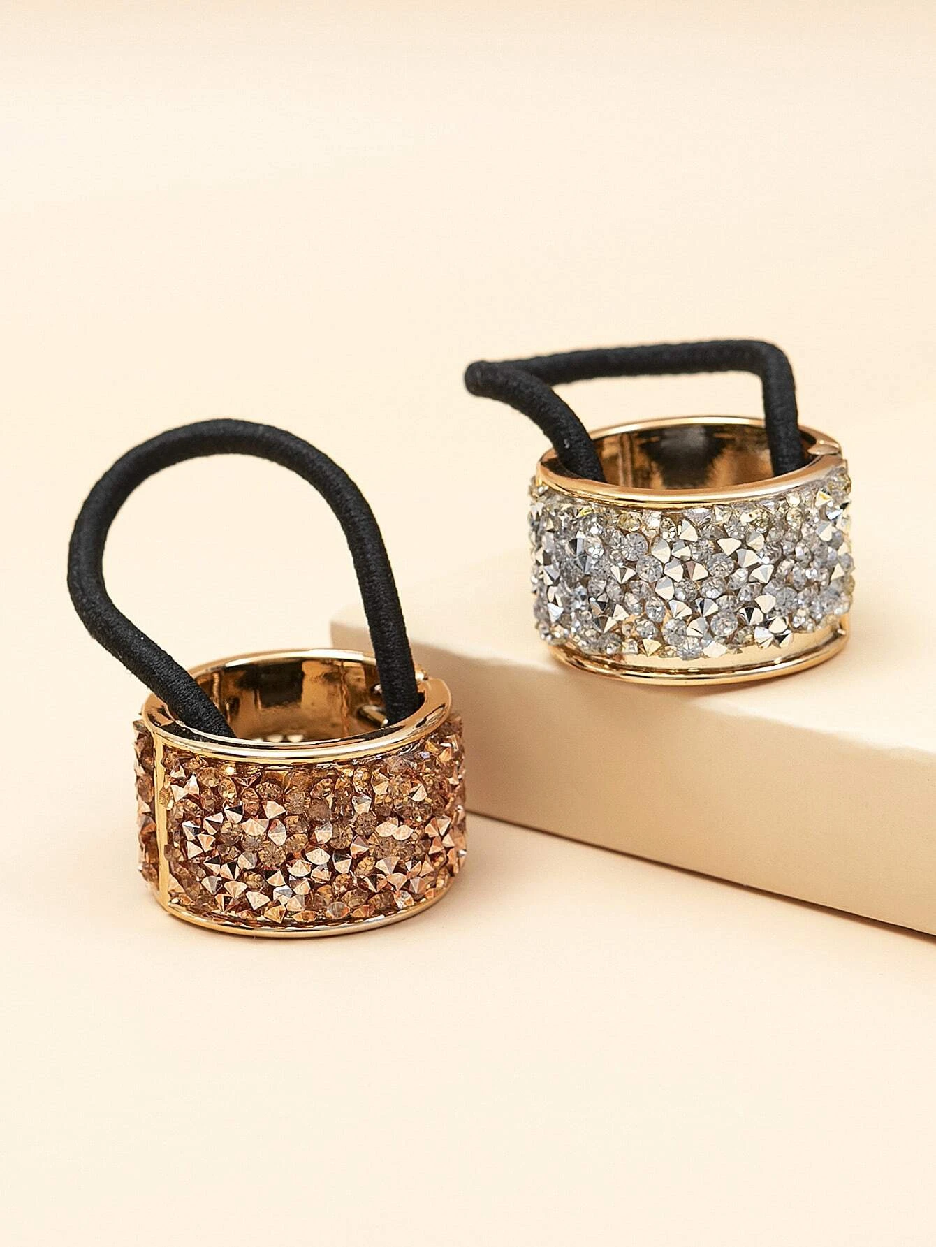 Two hair ties embellished with dazzling rhinestone decorations, perfect for adding a touch of sparkle and style to your hair.