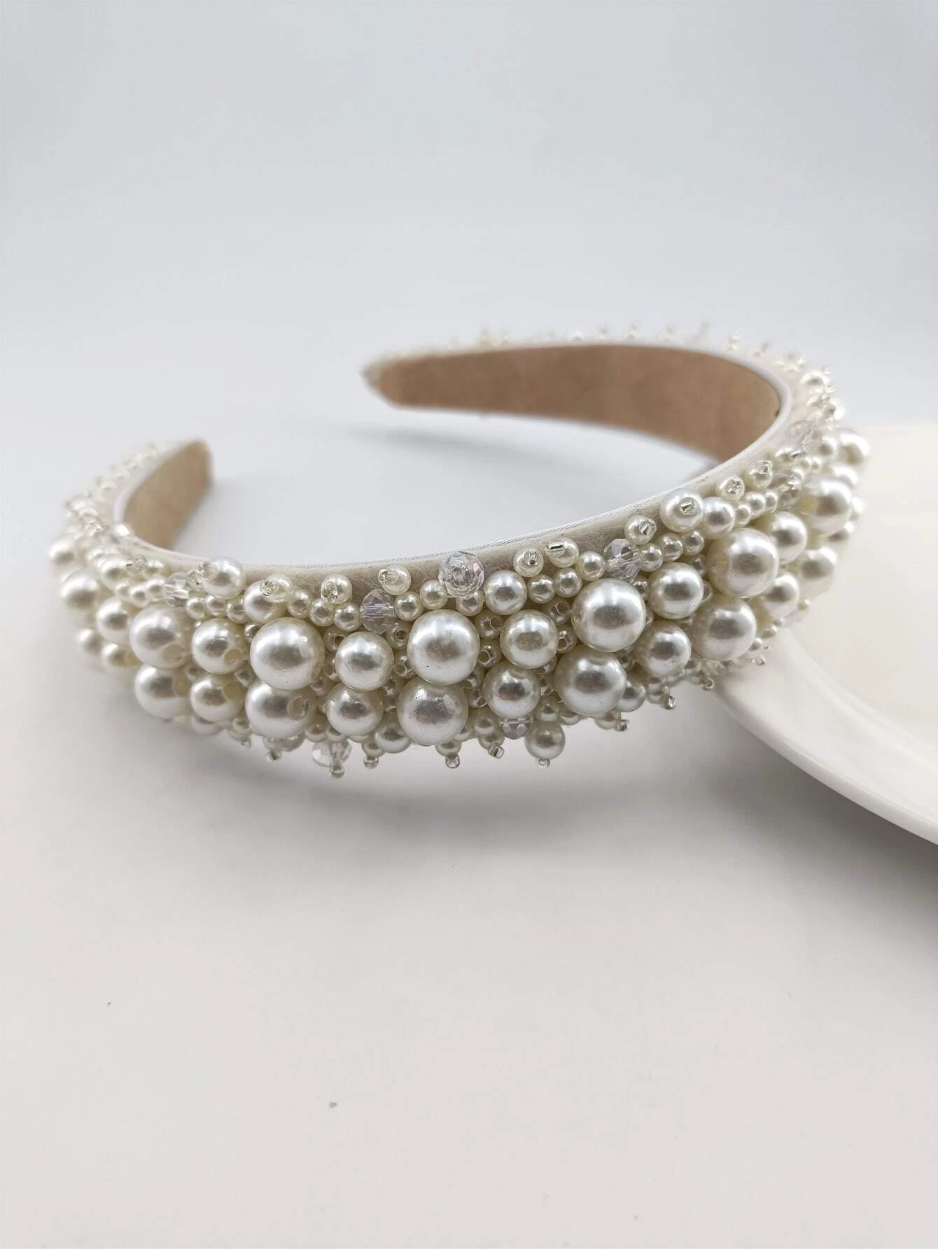Headband adorned with faux pearls, offering a blend of sophistication and fashion for various looks.