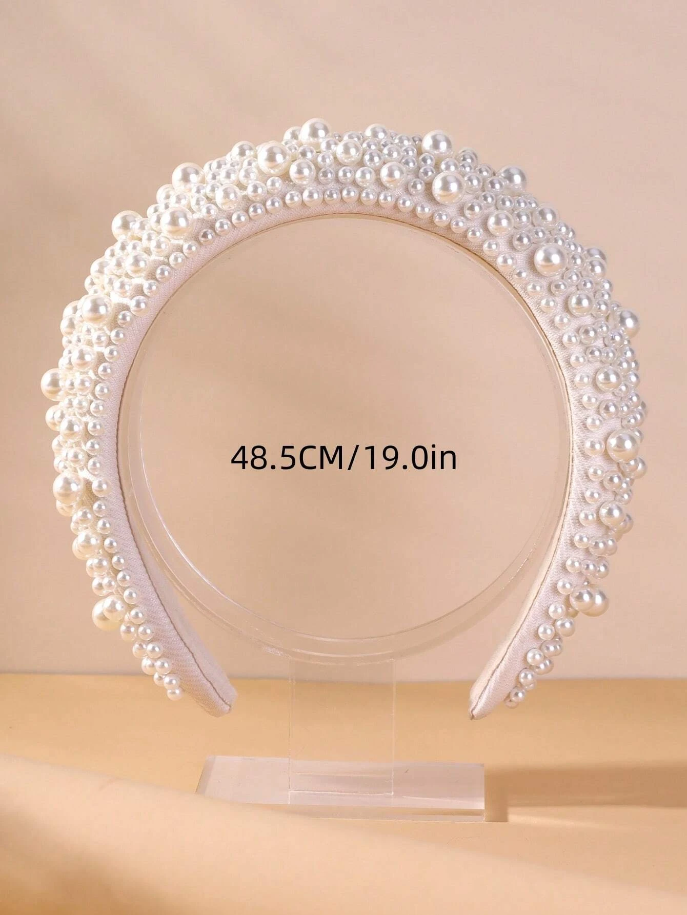 Wide headband adorned with white faux pearls, offering a chic and stylish accessory to elevate your hair look.