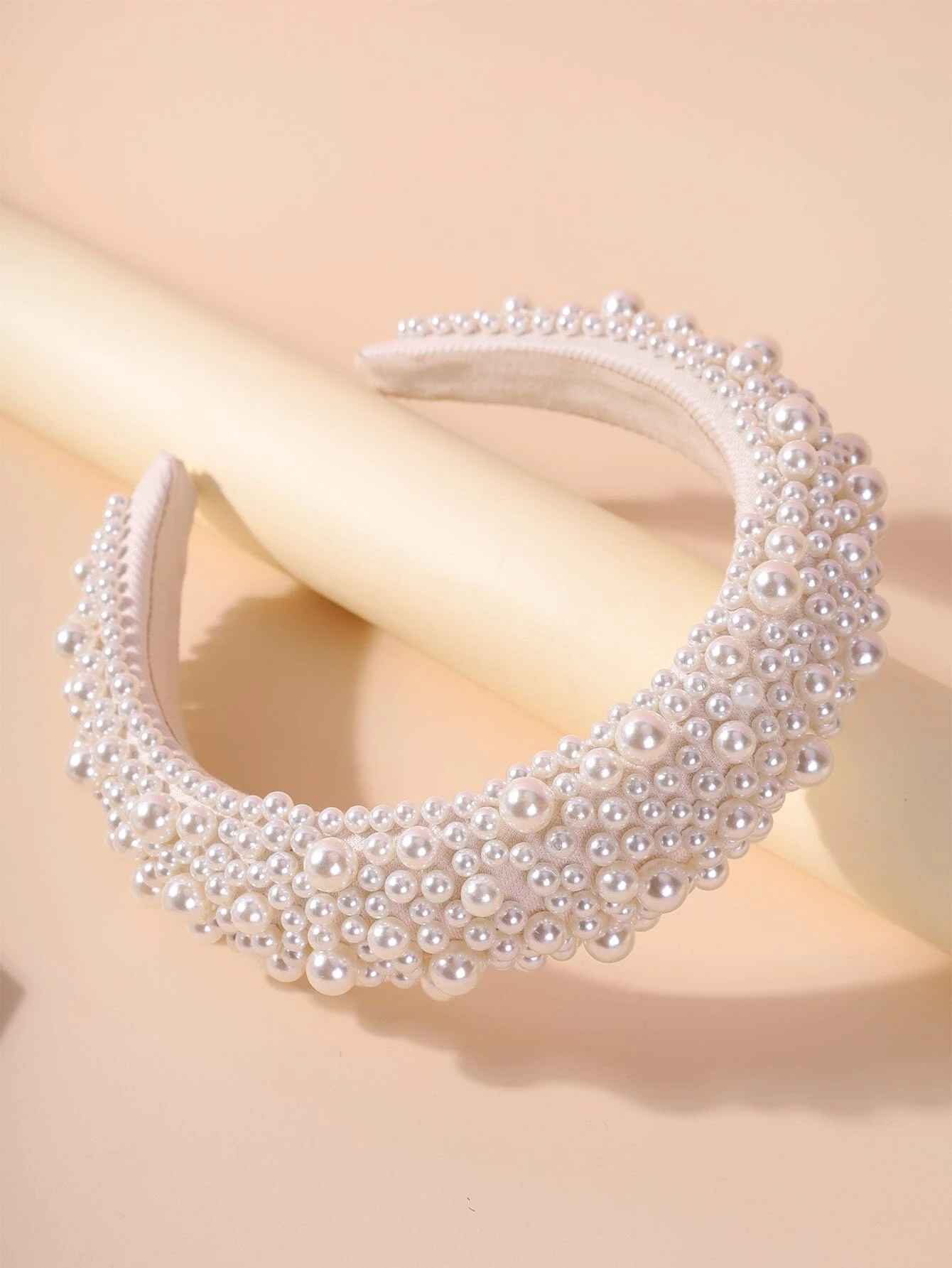 Wide headband adorned with white faux pearls, offering a chic and stylish accessory to elevate your hair look.