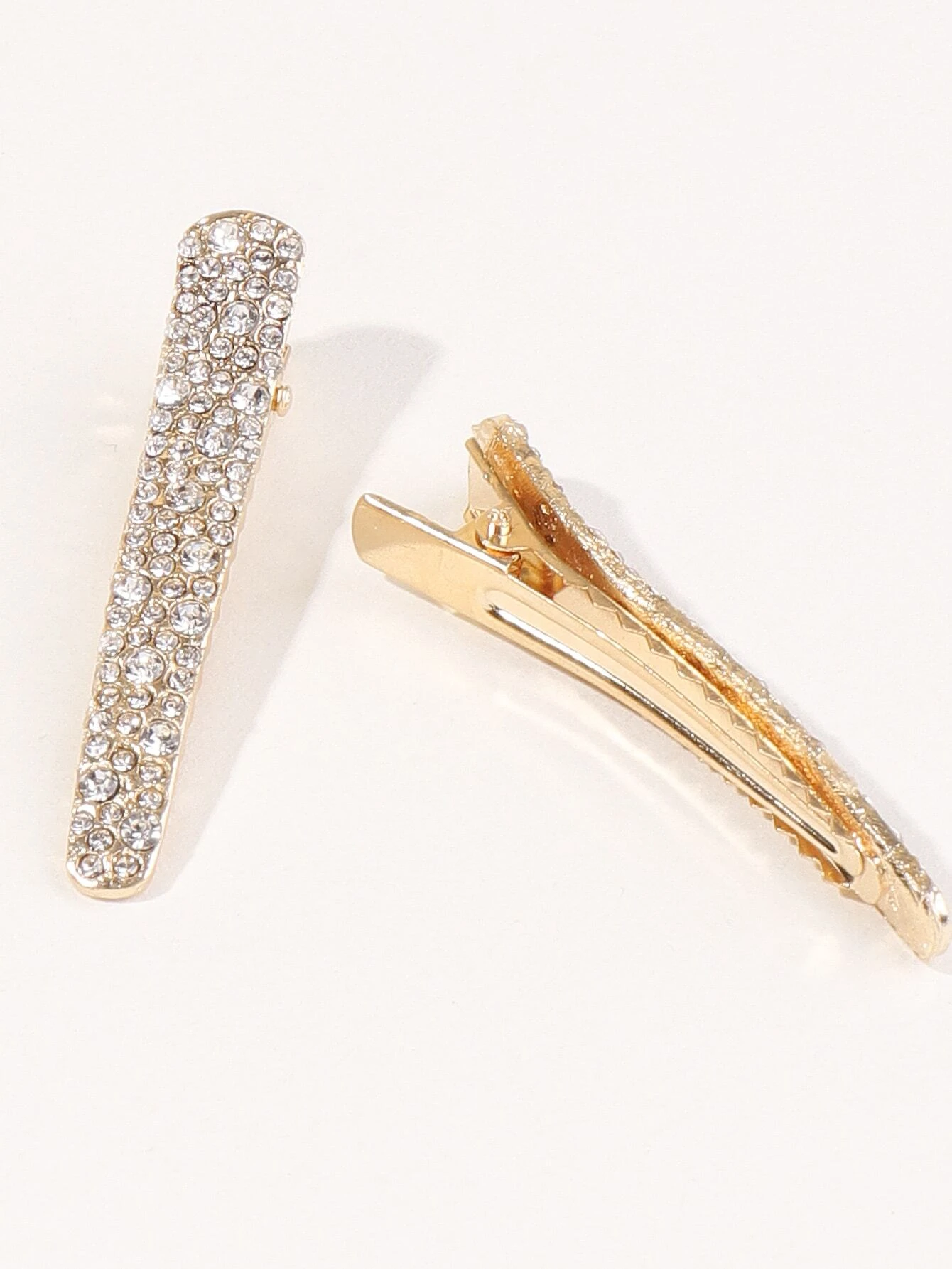 Two hair clips adorned with shimmering rhinestone decorations, adding a touch of elegance and glamour to your hairdo.