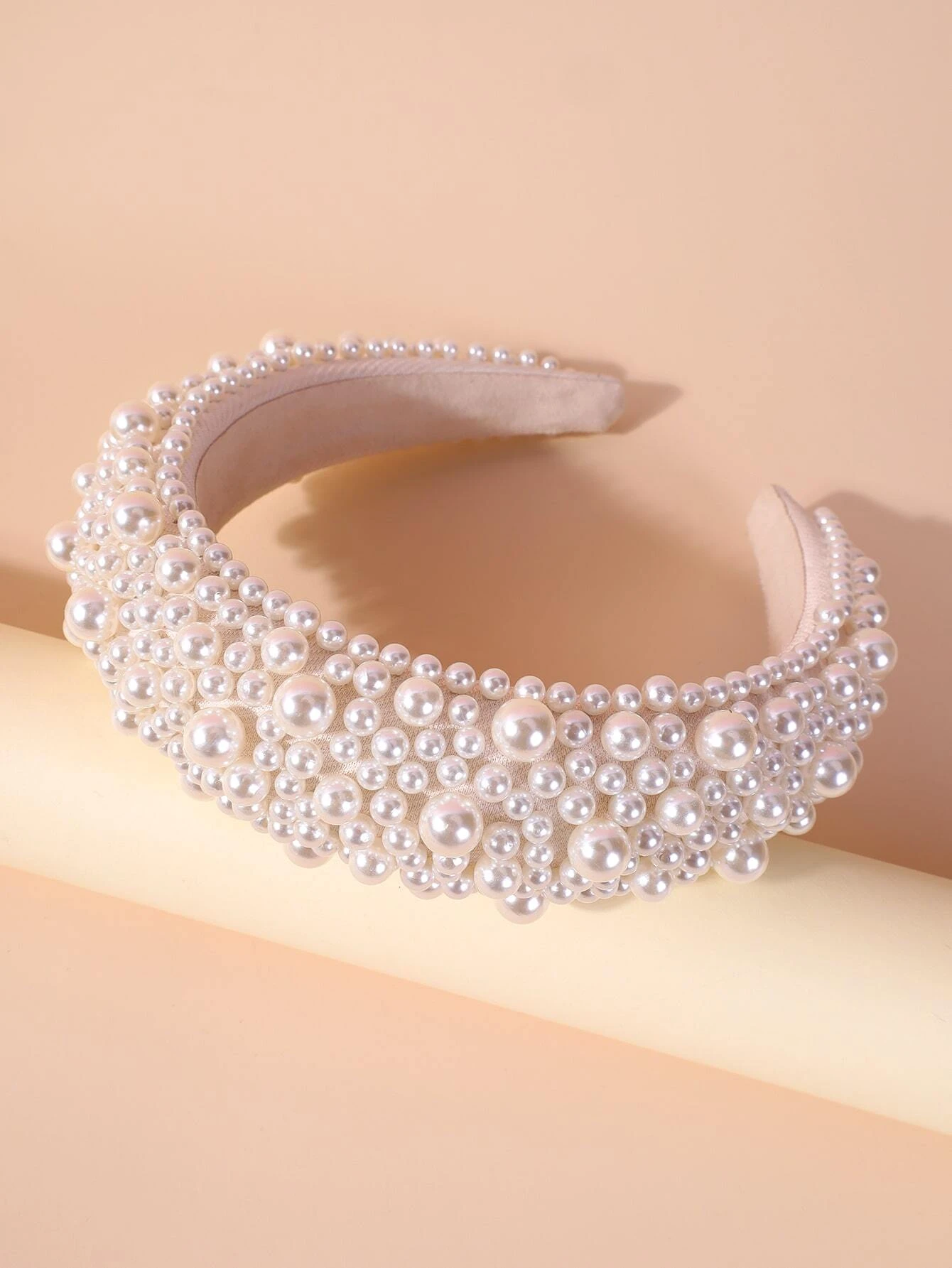 Wide headband adorned with white faux pearls, offering a chic and stylish accessory to elevate your hair look.