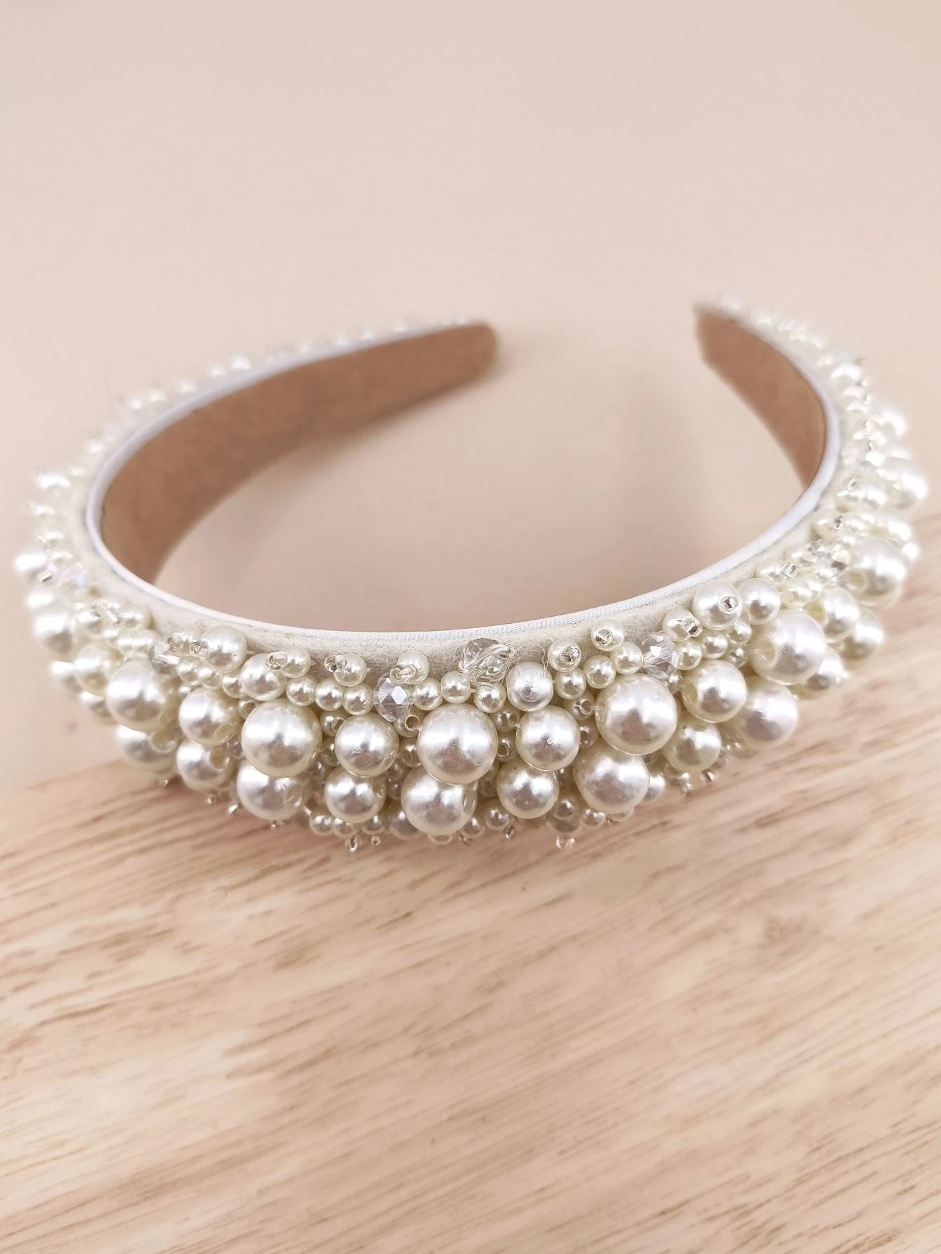 Headband adorned with faux pearls, offering a blend of sophistication and fashion for various looks.