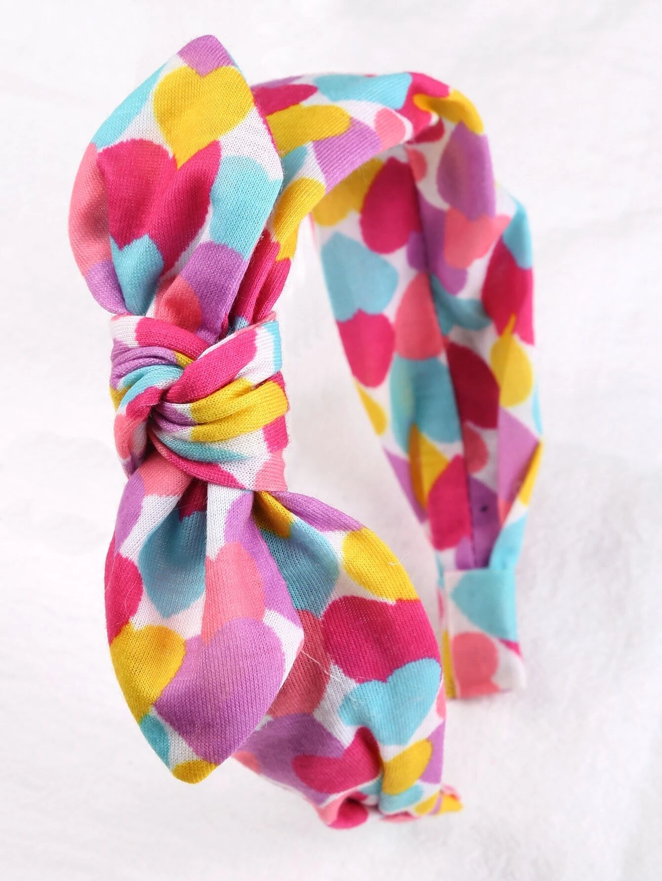Headband adorned with a heart print bow decoration, designed for toddler girls to add a cute and stylish accessory to their hair look.