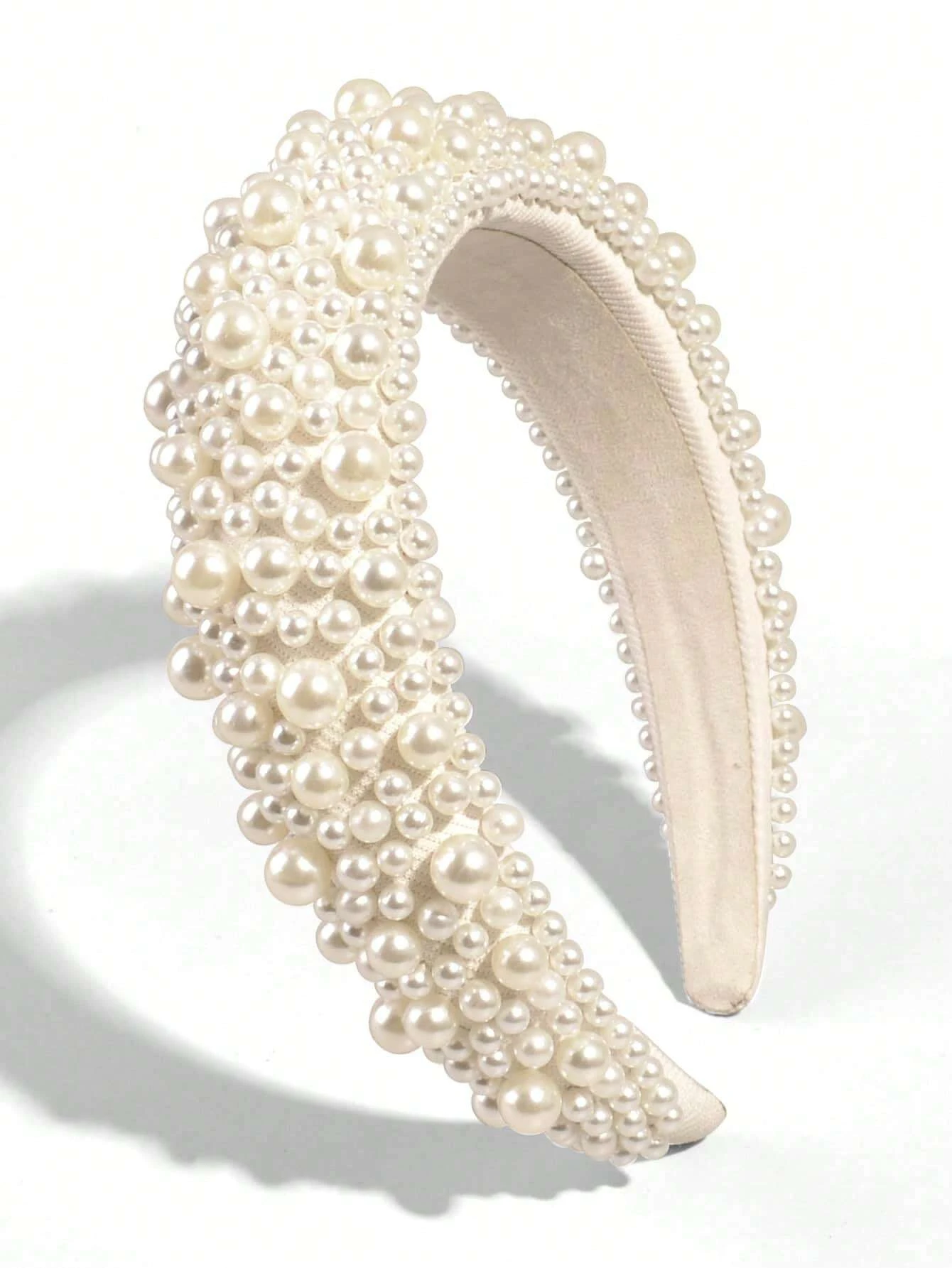Wide headband adorned with white faux pearls, offering a chic and stylish accessory to elevate your hair look.