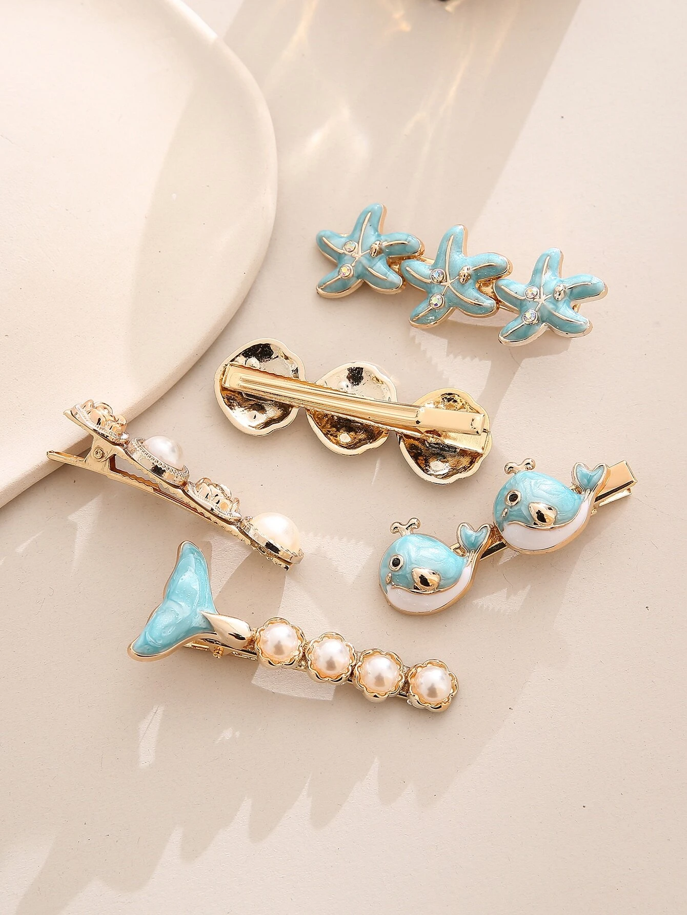 A set of five boho hair clips featuring starfish and shell decorations, adding a beachy and whimsical touch to your hair styling.