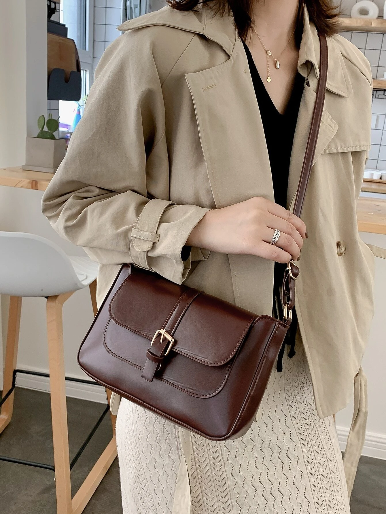 Flap crossbody bag with decorative buckle accent. This bag combines practicality and fashion, featuring a flap closure adorned with a stylish buckle for a chic and functional accessory.