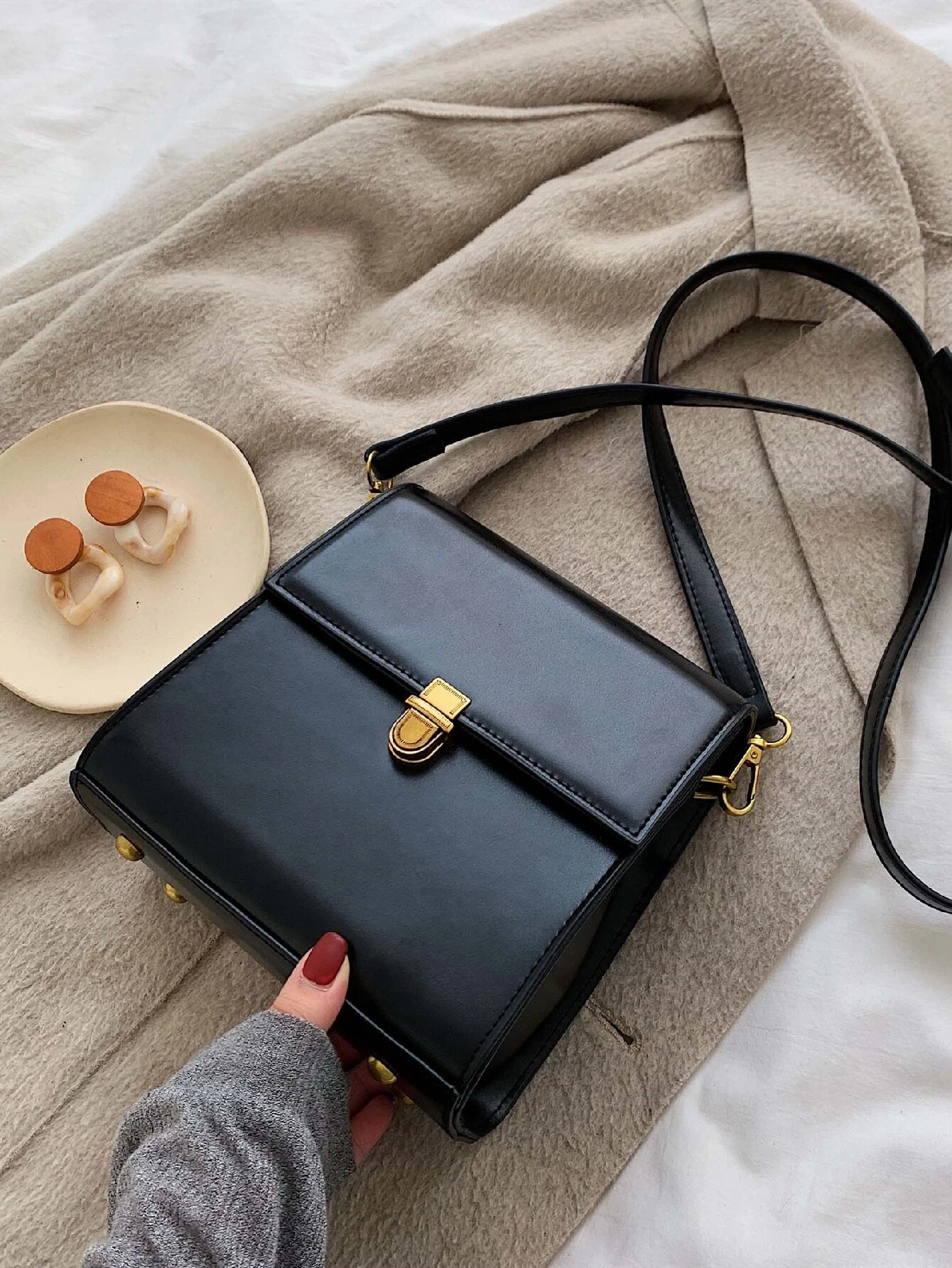 Mini square bag with minimalist design and snap button detail flap. This accessory combines simple elegance with functional embellishments, offering a chic and versatile way to carry your essentials.