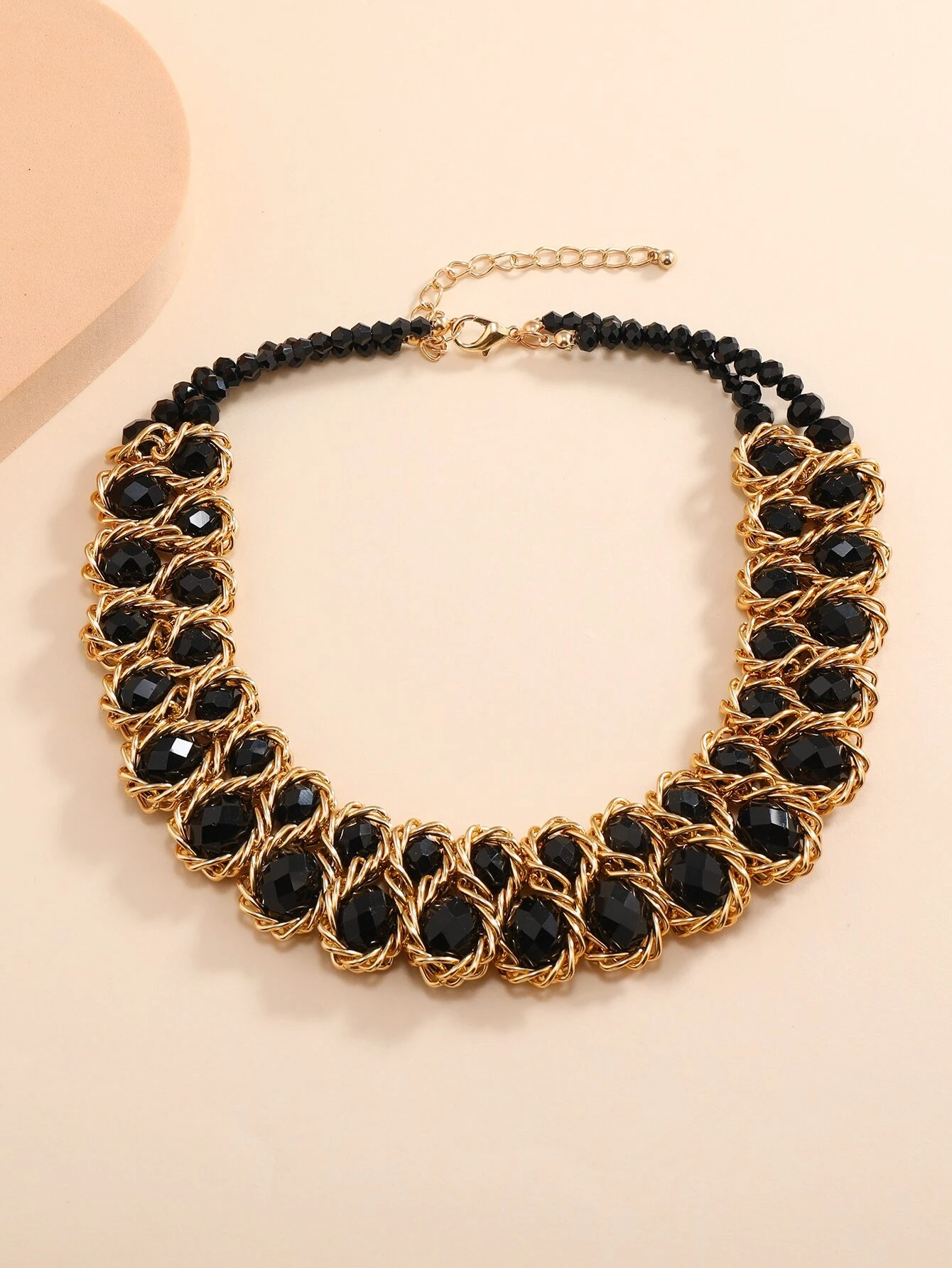 A necklace adorned with crystal decorations. The necklace features clear or colored crystals arranged in an artistic and eye-catching pattern. This accessory is elegant and versatile, adding a touch of sparkle and sophistication to various outfits.