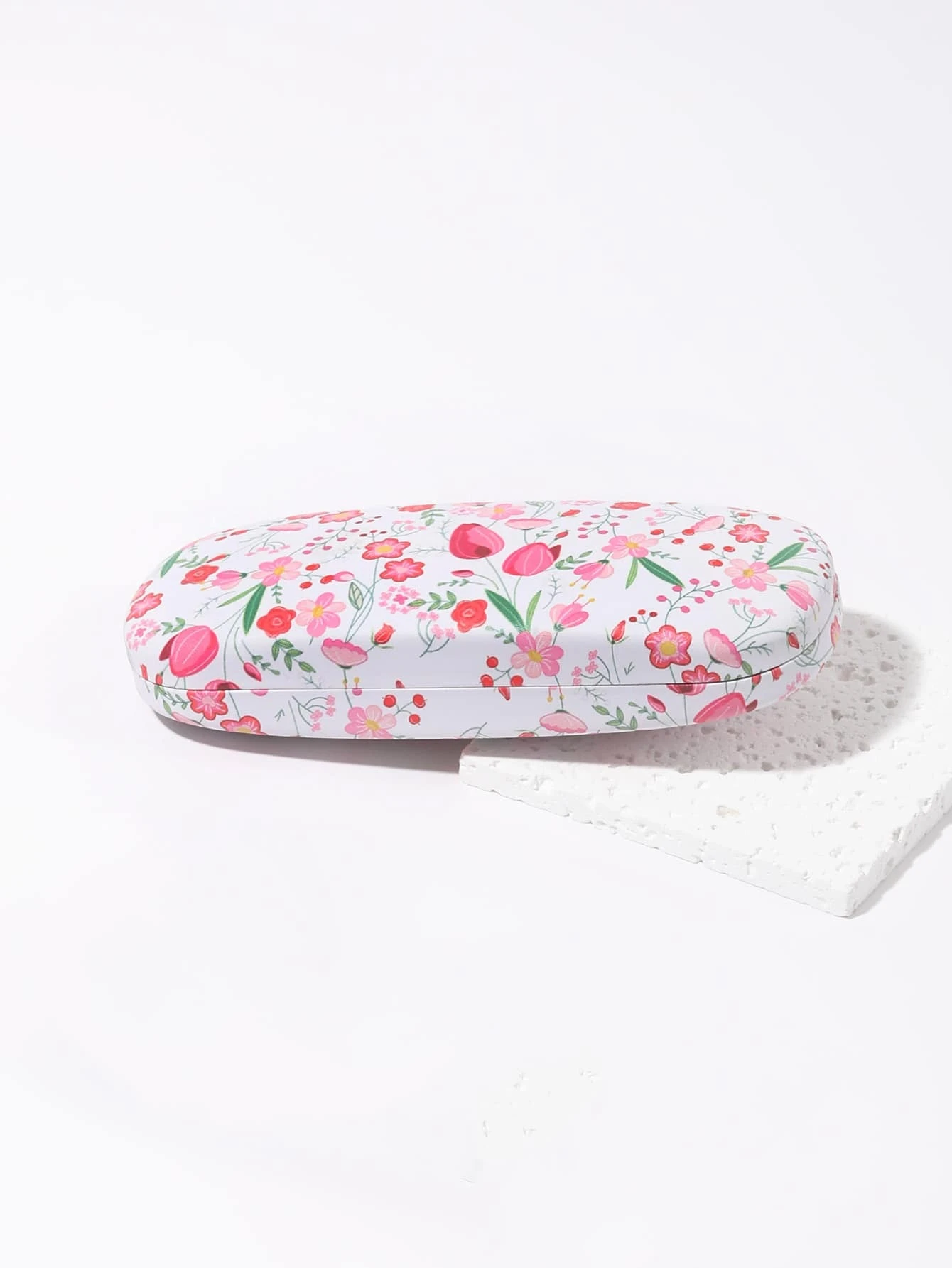 A glasses case featuring a floral print design. The case is designed to store and protect eyeglasses, sunglasses, or other optical frames. The floral print adds a touch of elegance and style to the case. This accessory is both functional and fashionable, offering a secure and stylish storage solution for eyewear.