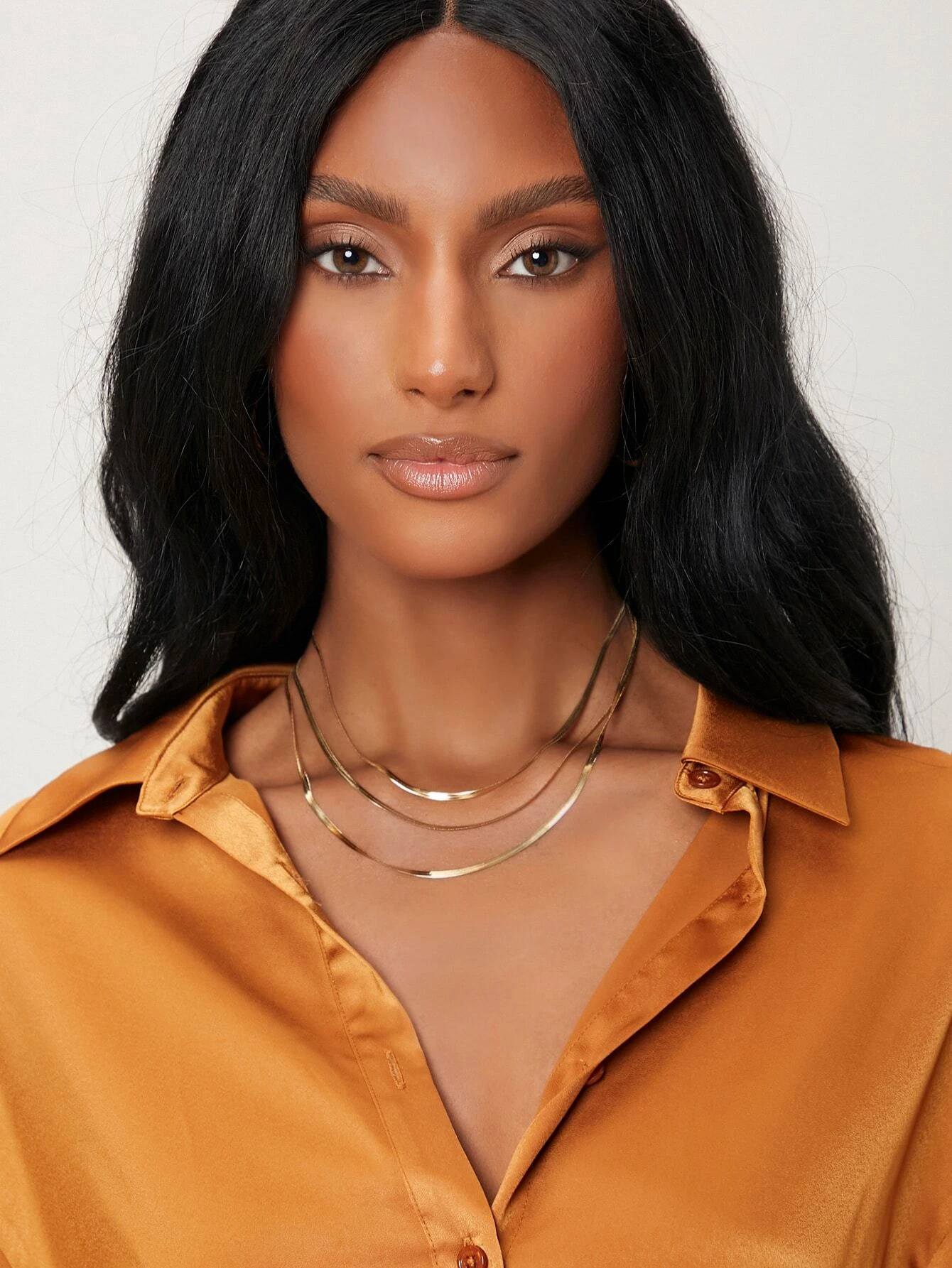 A layered necklace with a minimalist design. The necklace features delicate chains arranged in layers, creating a simple and elegant look. This accessory is modern and versatile, adding a touch of understated sophistication to various outfits