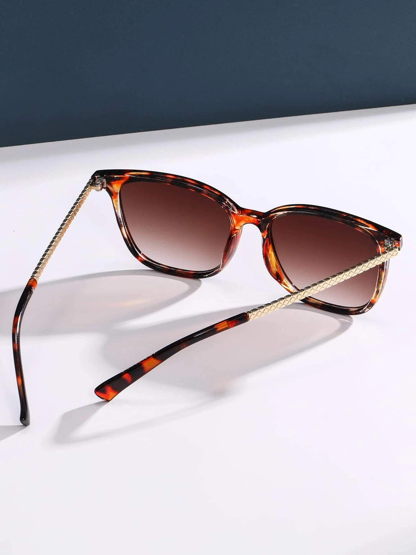 Stylish tortoiseshell frame sunglasses featuring a mottled pattern of rich browns and ambers. The oversized round lenses provide UV protection and a touch of vintage flair, while the sturdy frame design ensures both comfort and durability.