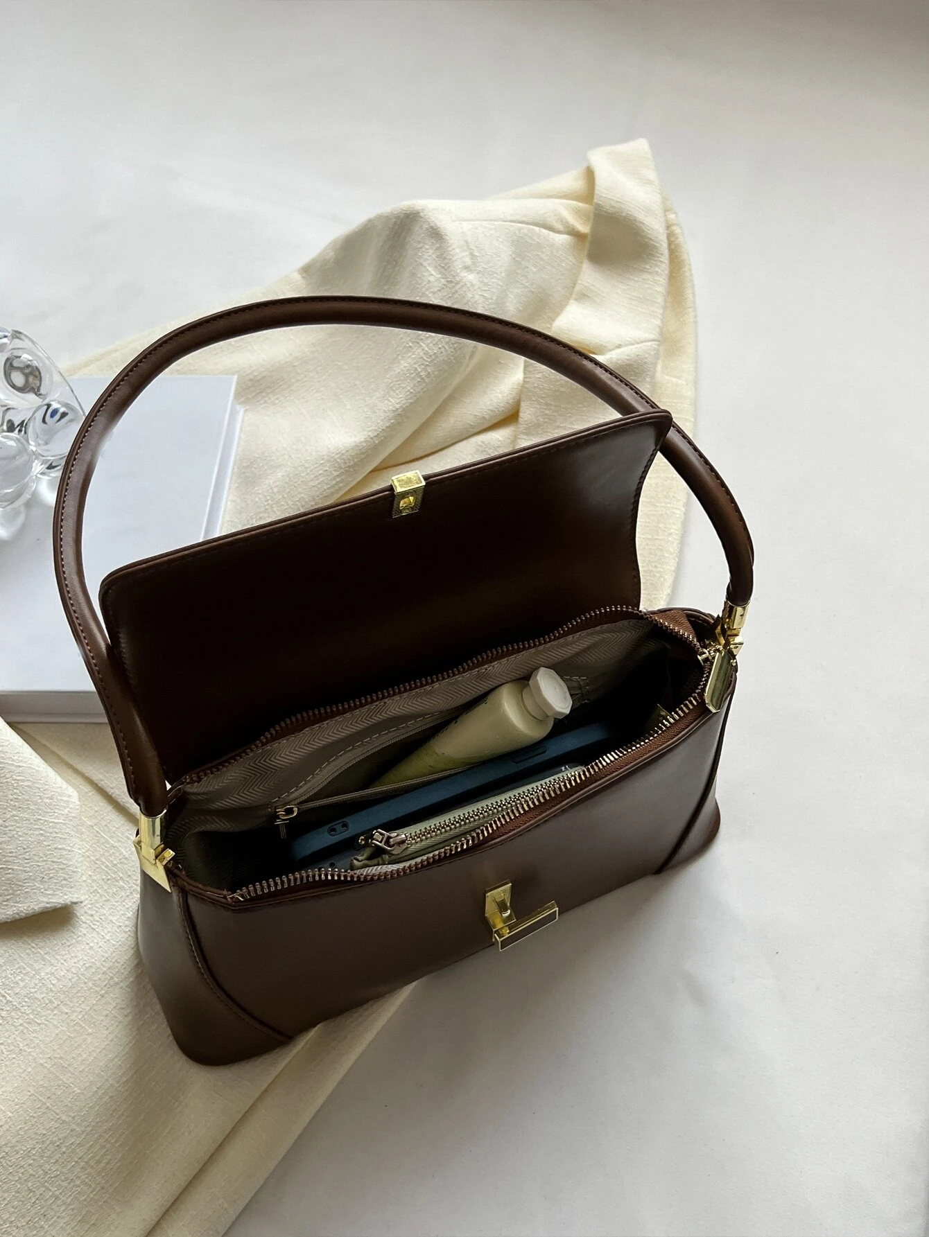 Flap baguette bag adorned with metal decorative elements. This accessory blends modern design with stylish embellishments, offering a chic and eye-catching way to carry your essentials.