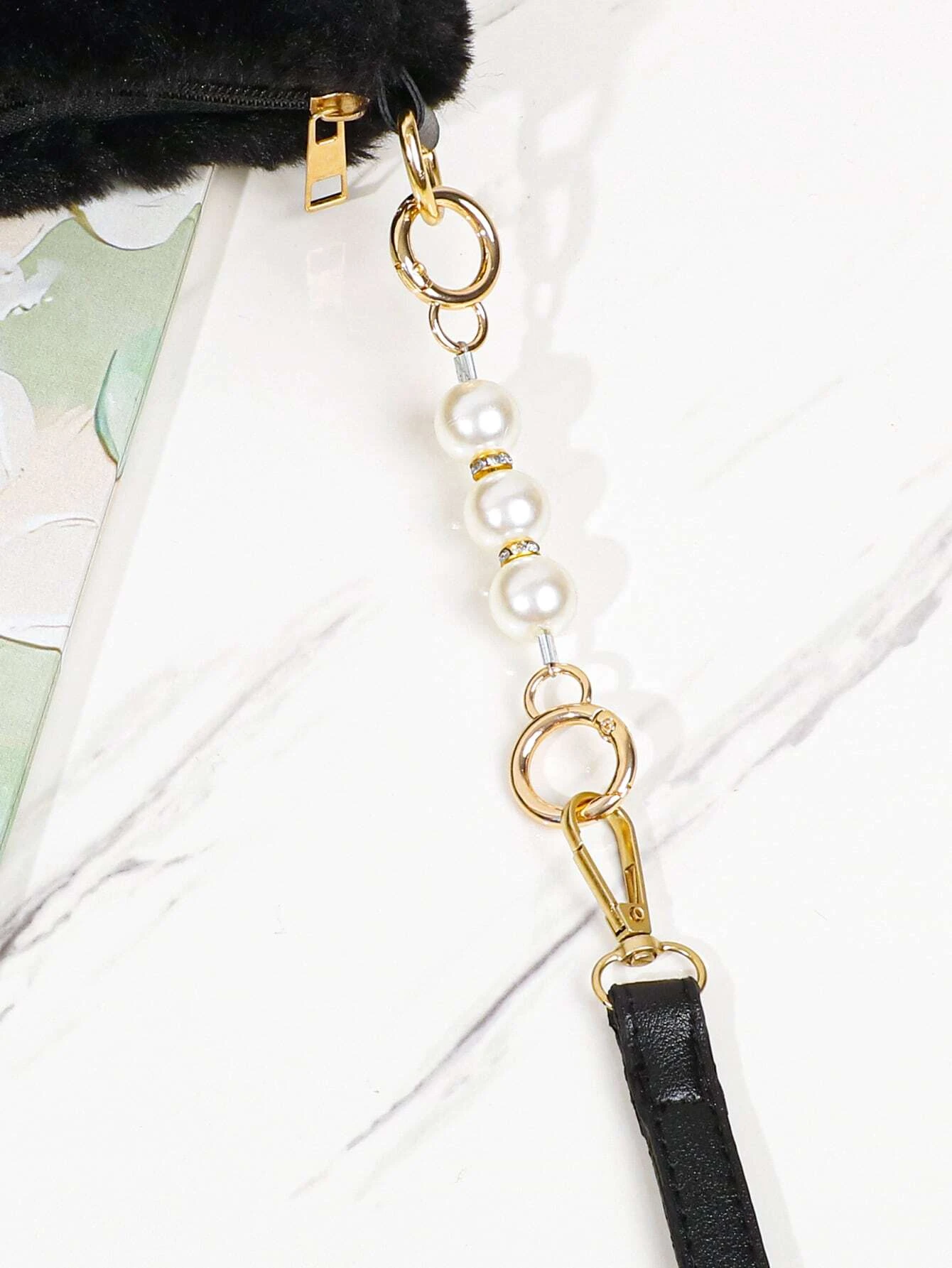 Bag strap adorned with rhinestone and faux pearl decorations. This accessory adds a touch of glamour and elegance to your bag, with its sparkling and pearl-adorned design enhancing its visual appeal.