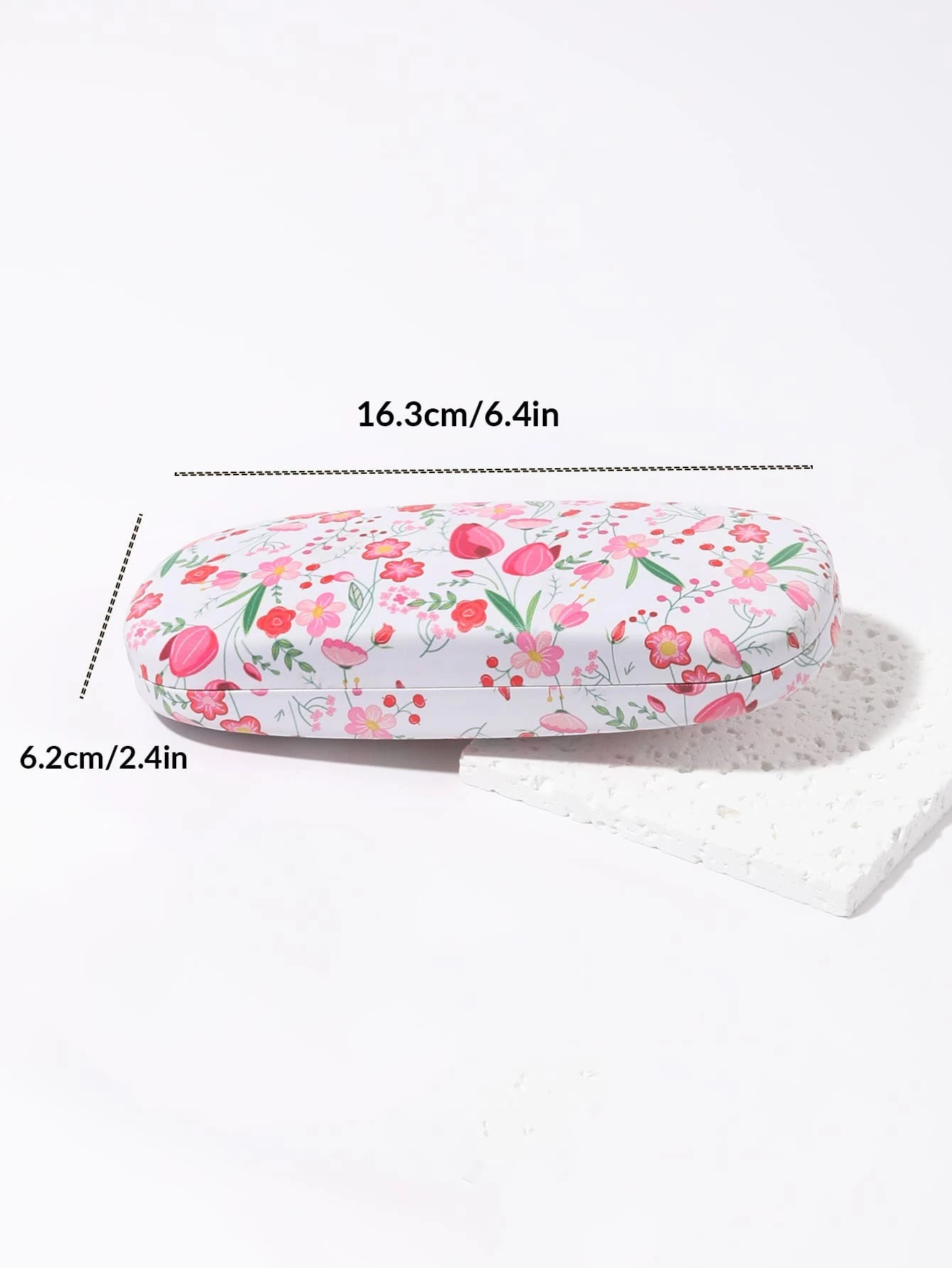 A glasses case featuring a floral print design. The case is designed to store and protect eyeglasses, sunglasses, or other optical frames. The floral print adds a touch of elegance and style to the case. This accessory is both functional and fashionable, offering a secure and stylish storage solution for eyewear.