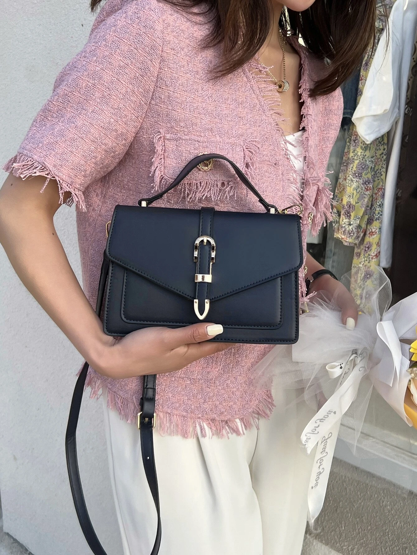 Minimalist navy blue square bag with metal decorative elements and flap closure. This accessory combines modern design with stylish embellishments, offering a chic and visually appealing way to carry your essentials.
