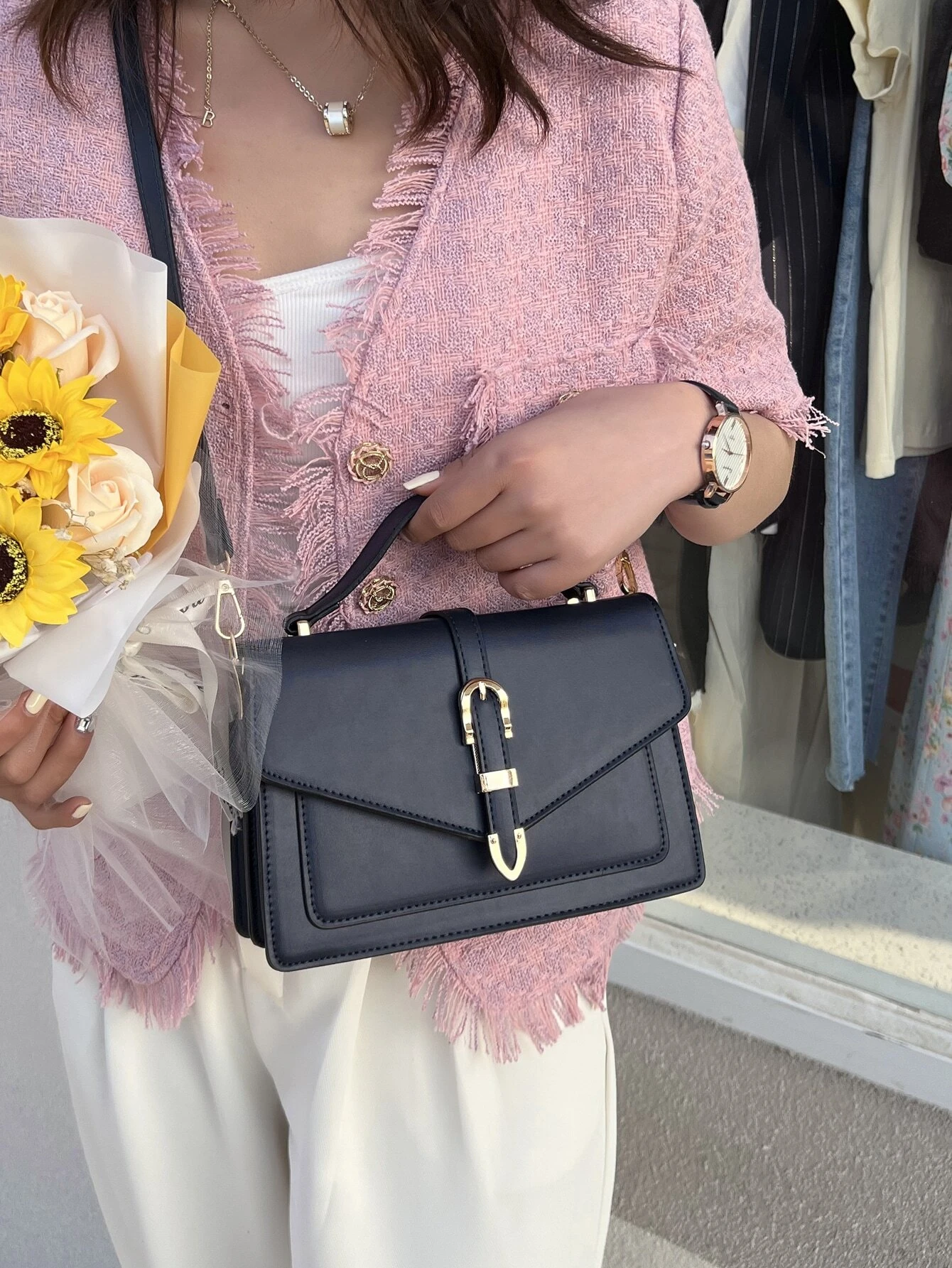 Minimalist navy blue square bag with metal decorative elements and flap closure. This accessory combines modern design with stylish embellishments, offering a chic and visually appealing way to carry your essentials.