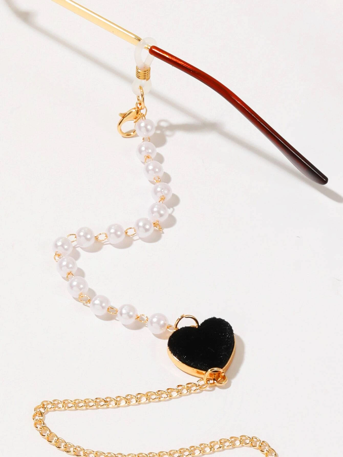 Heart and faux pearl decorated glasses chain, a chic and functional accessory for keeping eyeglasses or sunglasses secure, with a touch of elegance and charm.