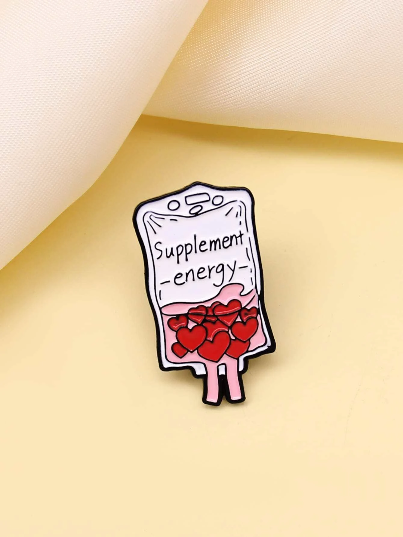 Brooch featuring a combination of heart and letter graphics, creating a charming and personalized accessory with a touch of romantic sentiment.