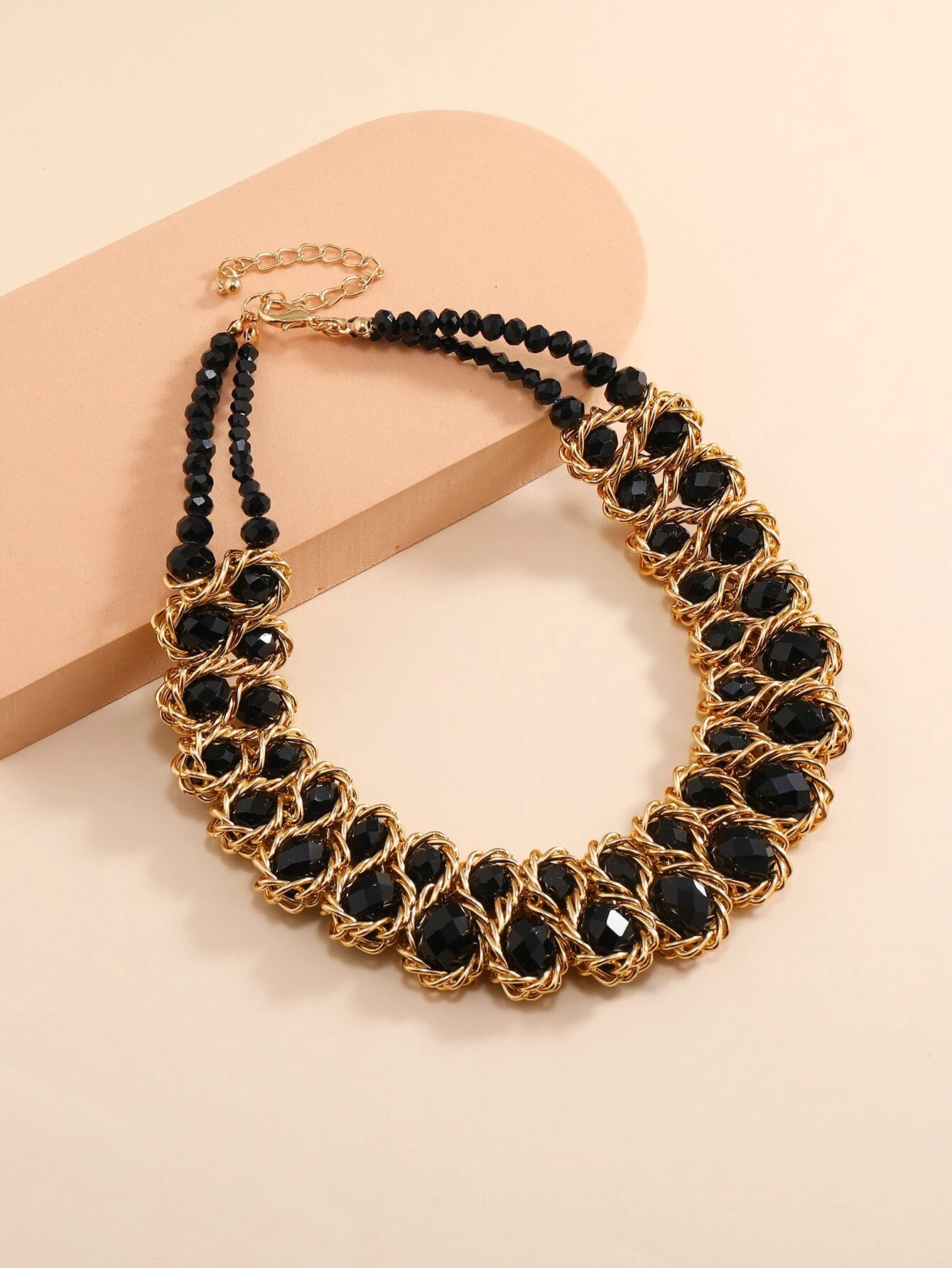 A necklace adorned with crystal decorations. The necklace features clear or colored crystals arranged in an artistic and eye-catching pattern. This accessory is elegant and versatile, adding a touch of sparkle and sophistication to various outfits.