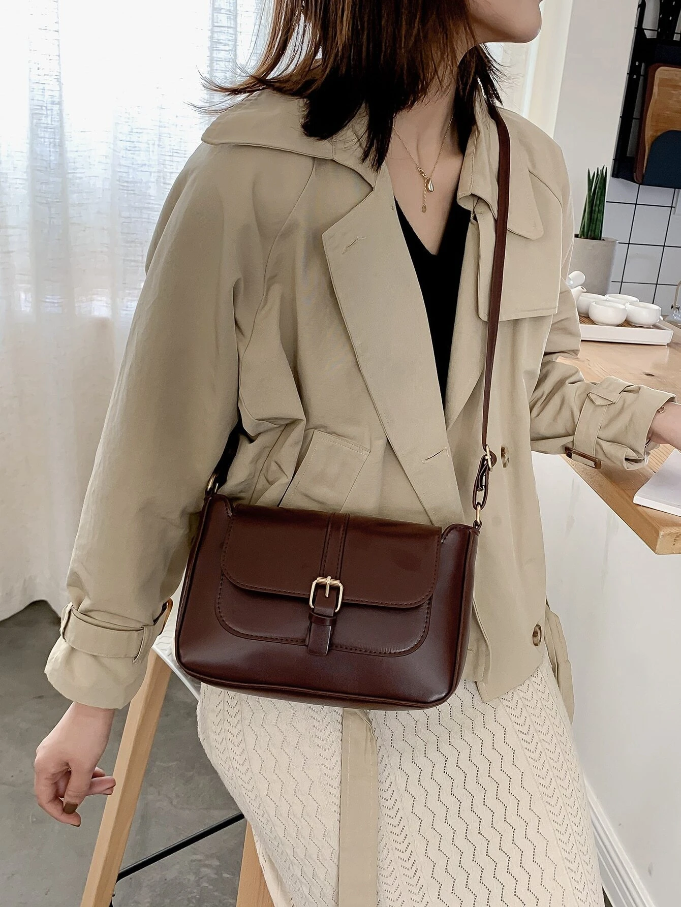 Flap crossbody bag with decorative buckle accent. This bag combines practicality and fashion, featuring a flap closure adorned with a stylish buckle for a chic and functional accessory.