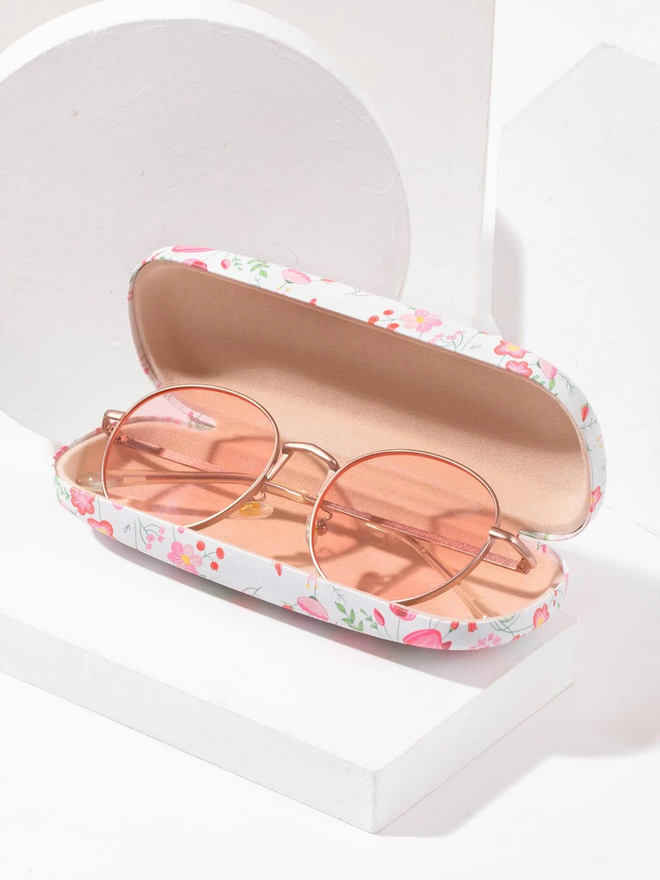A glasses case featuring a floral print design. The case is designed to store and protect eyeglasses, sunglasses, or other optical frames. The floral print adds a touch of elegance and style to the case. This accessory is both functional and fashionable, offering a secure and stylish storage solution for eyewear.