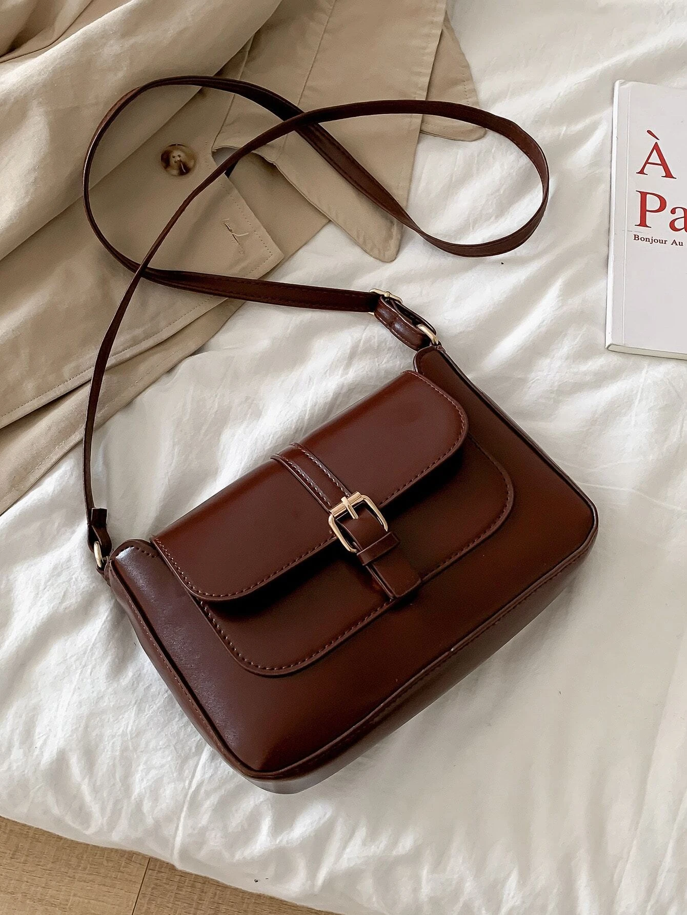 Flap crossbody bag with decorative buckle accent. This bag combines practicality and fashion, featuring a flap closure adorned with a stylish buckle for a chic and functional accessory.