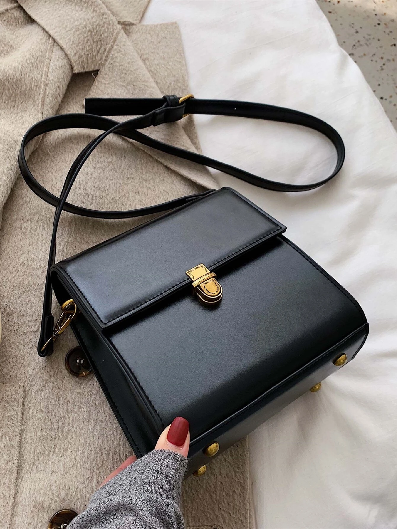 Mini square bag with minimalist design and snap button detail flap. This accessory combines simple elegance with functional embellishments, offering a chic and versatile way to carry your essentials.