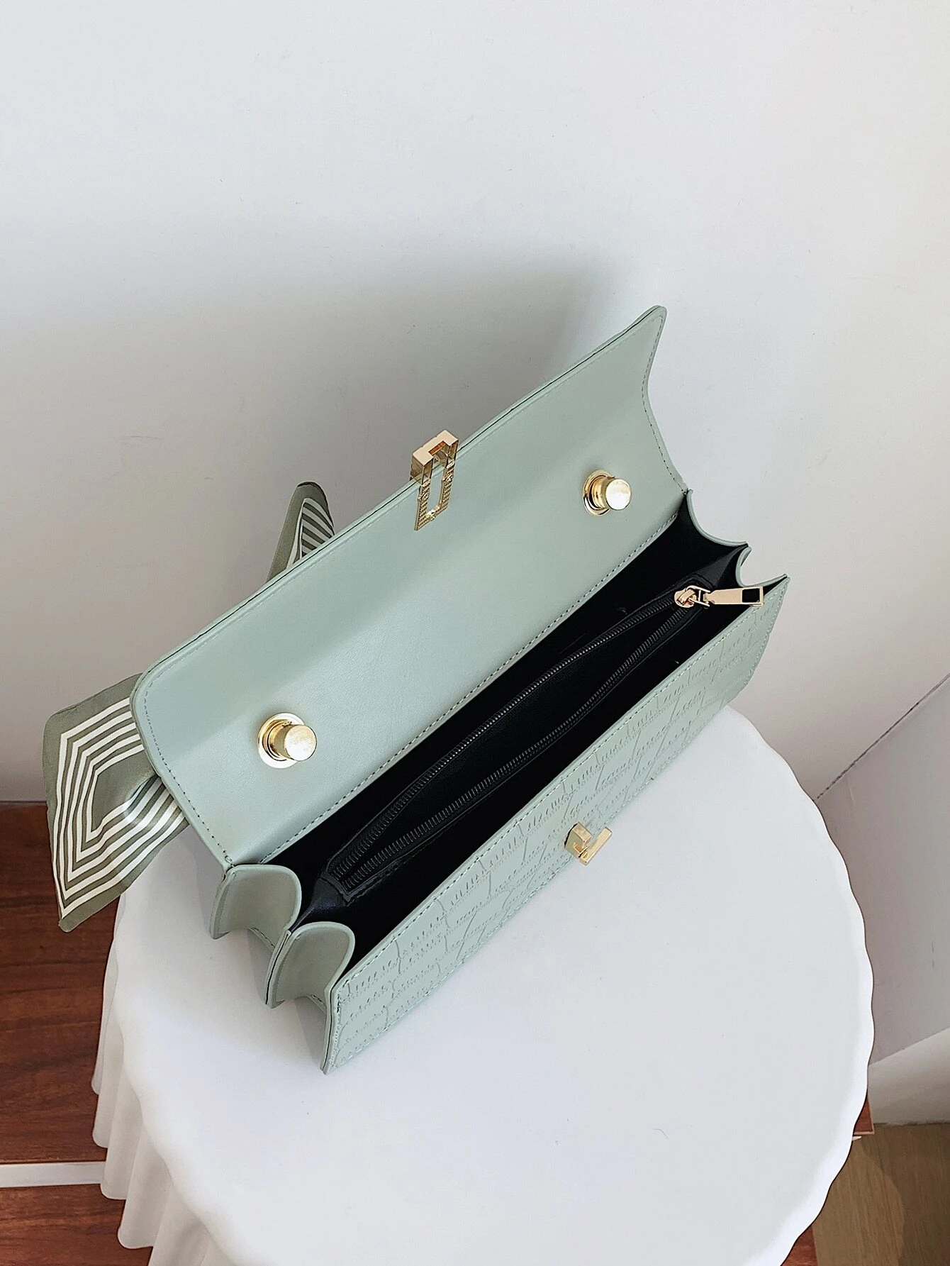 Crocodile embossed flap square bag with twilly decoration. This accessory blends sophisticated texture with stylish embellishments, offering a chic and visually appealing way to carry your essentials.