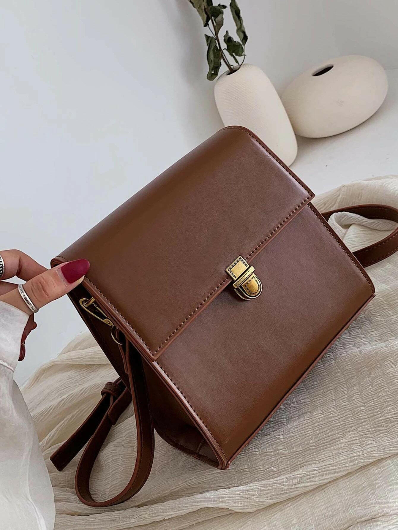 Push lock crossbody bag with minimalist design. This accessory combines practicality with clean lines, offering a sleek and versatile way to carry your essentials.