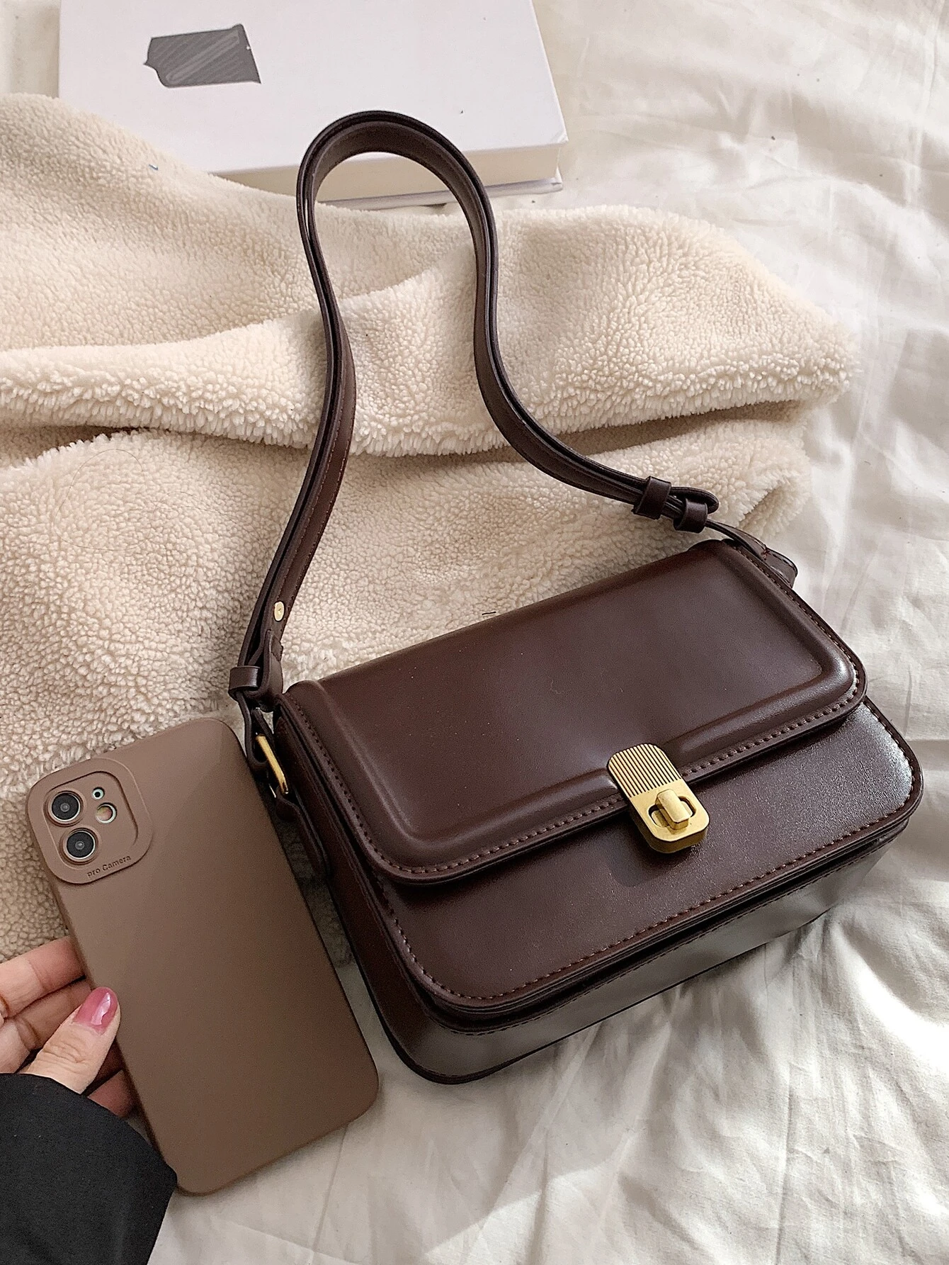 Square bag with twist lock flap closure. This accessory offers a chic and stylish way to carry your essentials, featuring a secure twist lock that enhances its functionality.