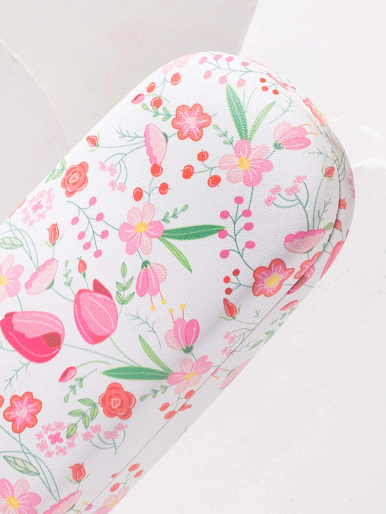 A glasses case featuring a floral print design. The case is designed to store and protect eyeglasses, sunglasses, or other optical frames. The floral print adds a touch of elegance and style to the case. This accessory is both functional and fashionable, offering a secure and stylish storage solution for eyewear.
