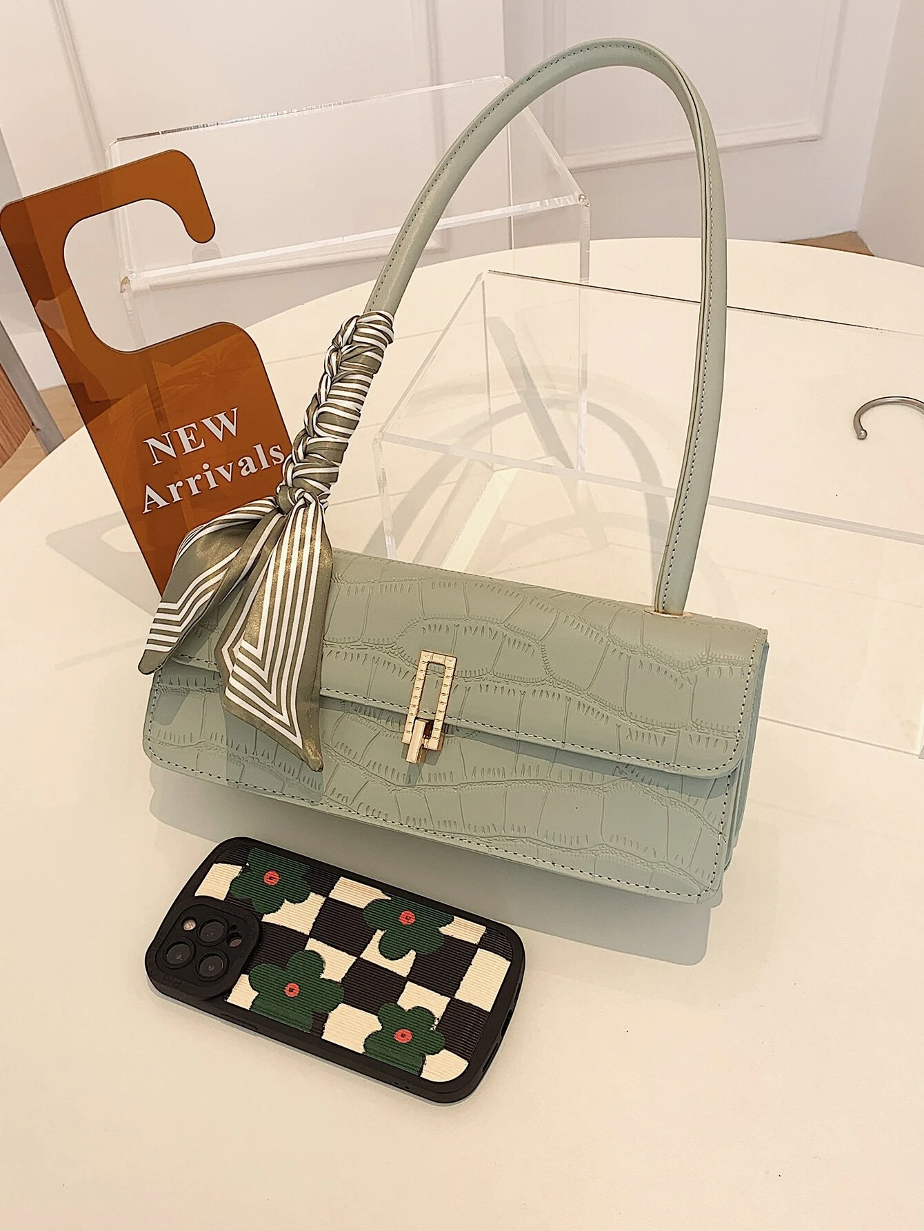 Crocodile embossed flap square bag with twilly decoration. This accessory blends sophisticated texture with stylish embellishments, offering a chic and visually appealing way to carry your essentials.