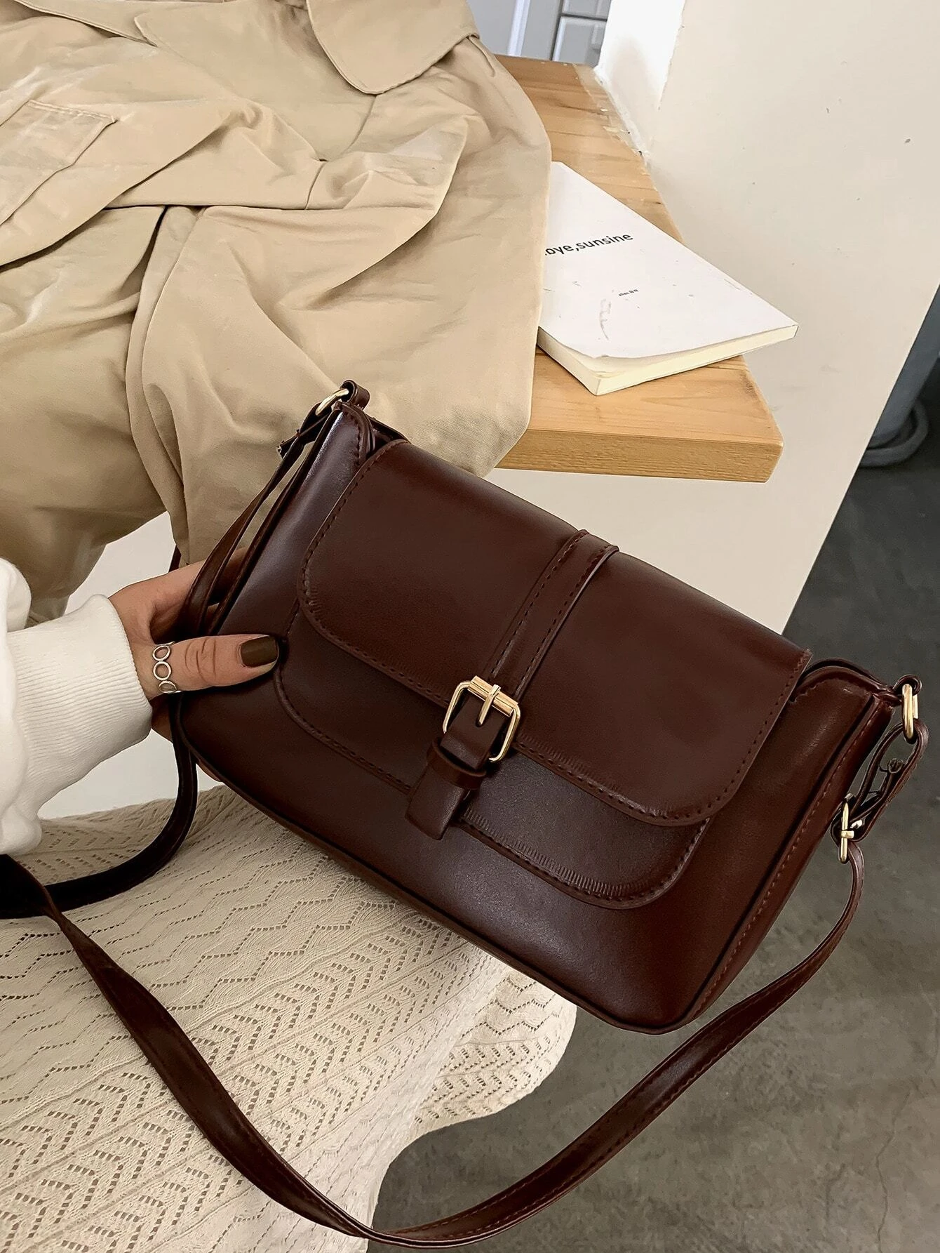 Flap crossbody bag with decorative buckle accent. This bag combines practicality and fashion, featuring a flap closure adorned with a stylish buckle for a chic and functional accessory.