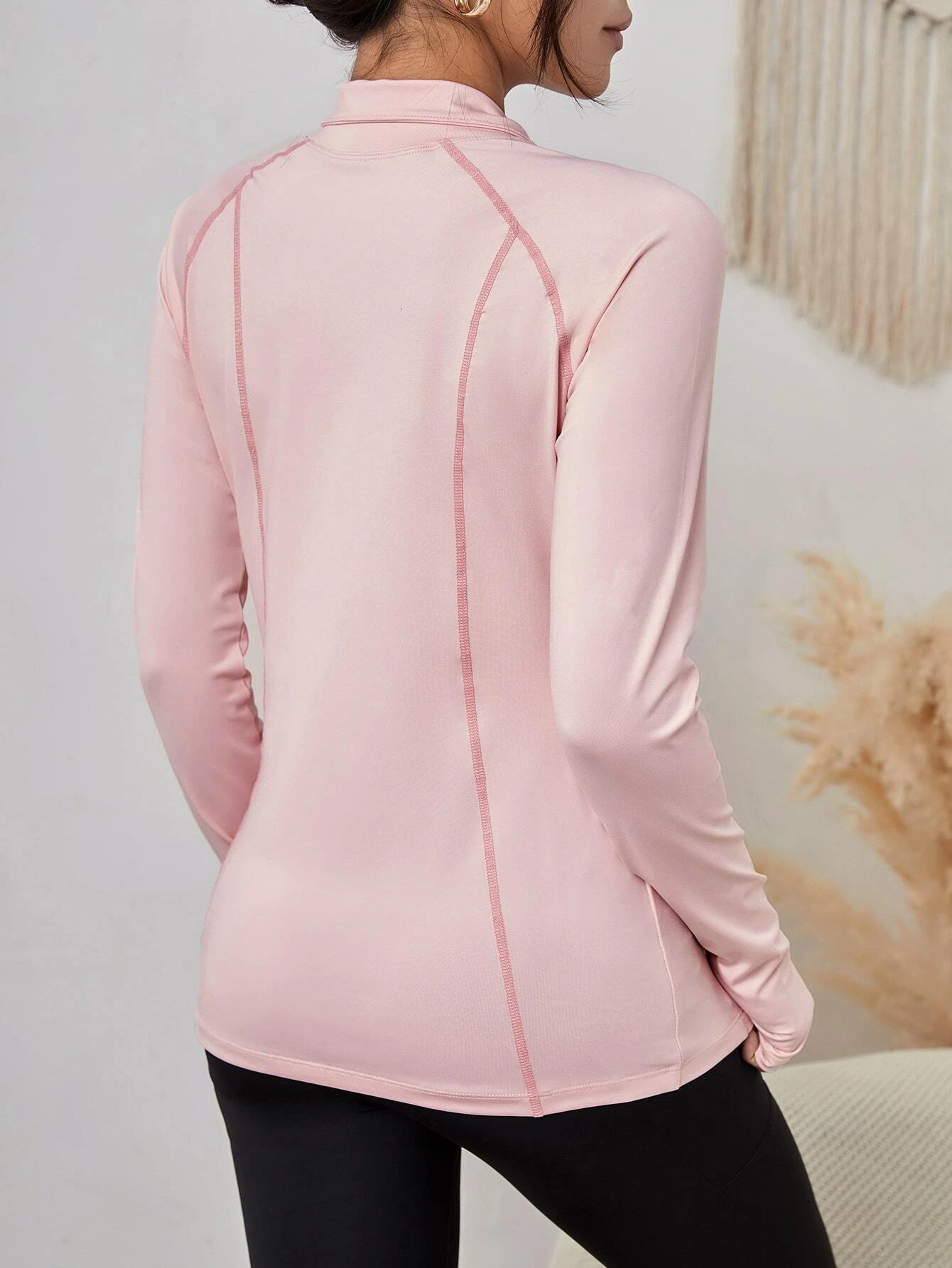 Image of a zip-up sports jacket with slant pockets and thumb holes. The jacket is designed to provide warmth during physical activities and features slant pockets and thumb holes for added functionality.