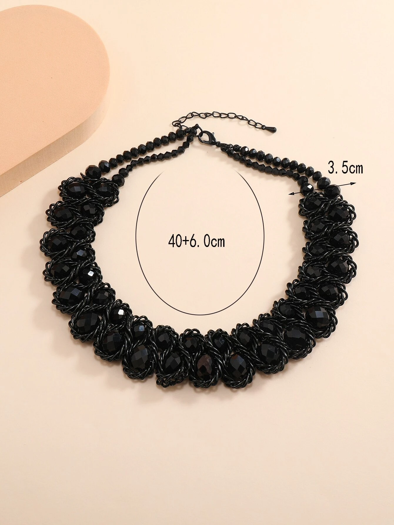 A layered necklace featuring multiple beads and chains arranged in a fashionable manner. The necklace showcases different layers of beads and chains, creating a stylish and textured look. This accessory is versatile and can complement various outfits, adding a touch of trendy elegance.