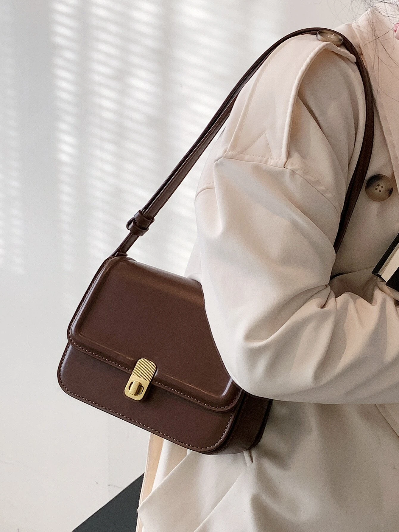 Square bag with twist lock flap closure. This accessory offers a chic and stylish way to carry your essentials, featuring a secure twist lock that enhances its functionality.