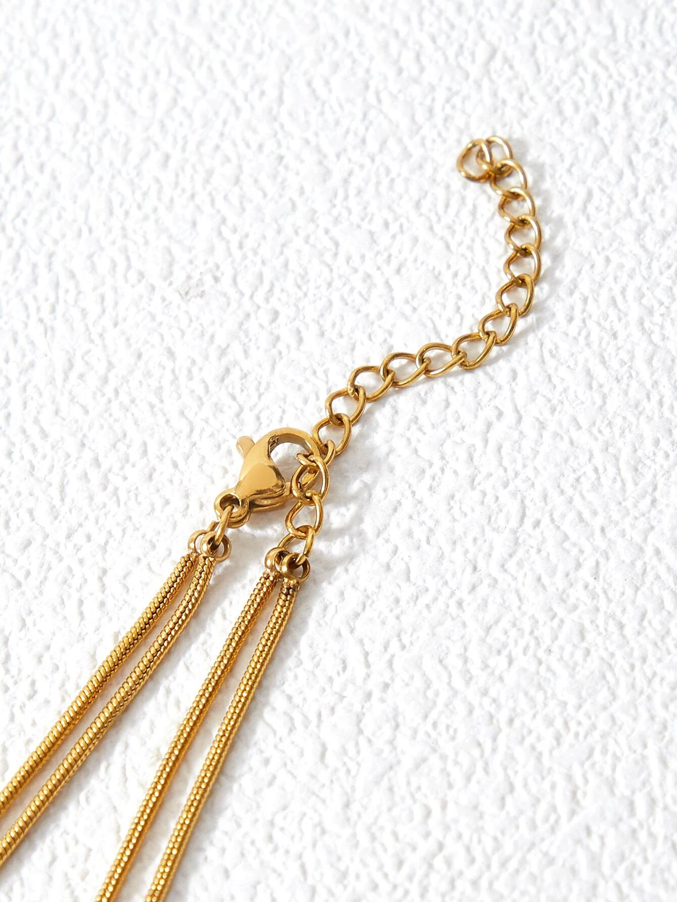 Layered necklace with round decorative elements. The necklace features multiple tiers of circular pendants in various sizes and textures, creating a visually dynamic and stylish piece. The interplay of metallic finishes and patterns adds depth to the design, making it a versatile and trendy accessory to elevate any outfit.