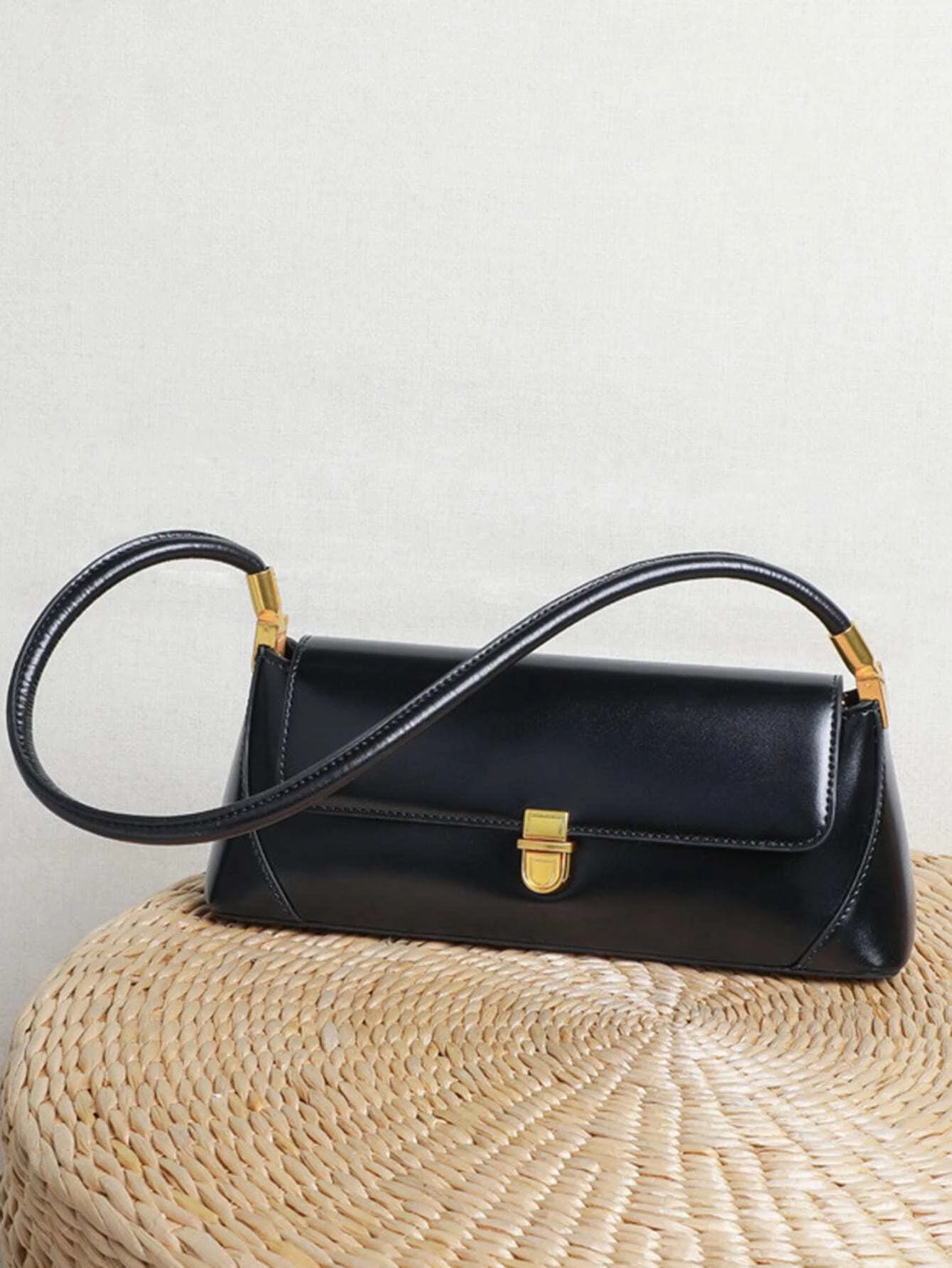 Flap baguette bag with minimalist design. This accessory offers a sleek and stylish way to carry your essentials, embodying modern elegance and functionality.