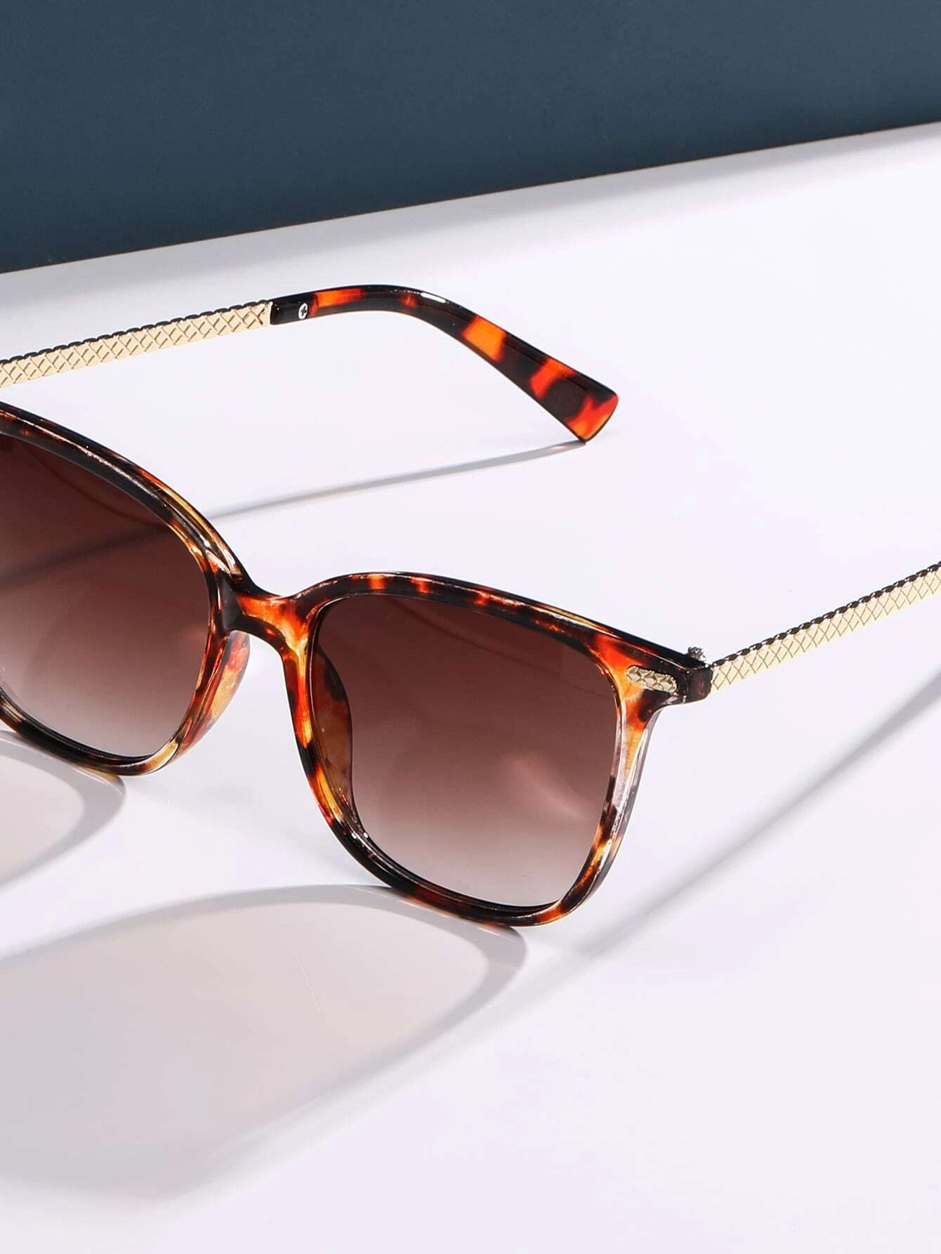 Stylish tortoiseshell frame sunglasses featuring a mottled pattern of rich browns and ambers. The oversized round lenses provide UV protection and a touch of vintage flair, while the sturdy frame design ensures both comfort and durability.