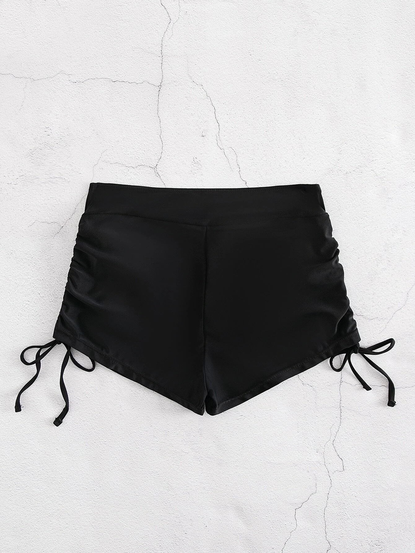 Bikini shorts with drawstring sides for adjustable fit. These shorts feature a versatile design with adjustable drawstring sides, allowing for a customizable and comfortable fit. The shorts are ideal for beach or pool activities and offer a trendy and practical swimwear option. The drawstring detail adds a touch of style while ensuring a secure and personalized fit, making these shorts a fashionable choice for any water-related outing.