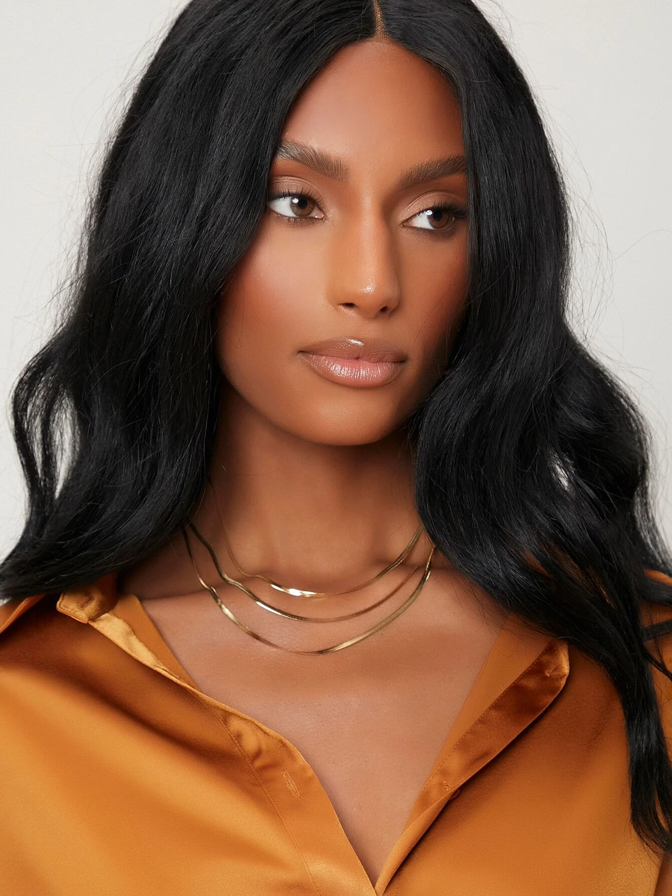 A layered necklace with a minimalist design. The necklace features delicate chains arranged in layers, creating a simple and elegant look. This accessory is modern and versatile, adding a touch of understated sophistication to various outfits