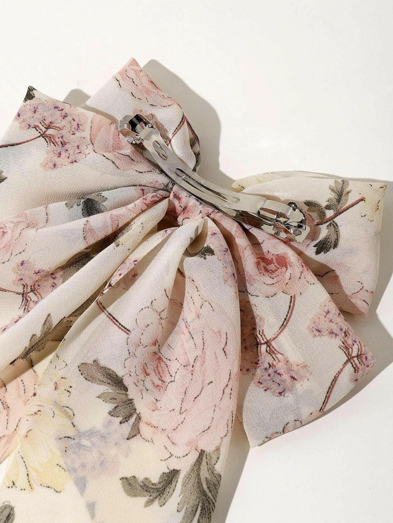 Hair clip with a bow and flower print decor, blending playful charm with floral motifs for a delightful accessory.