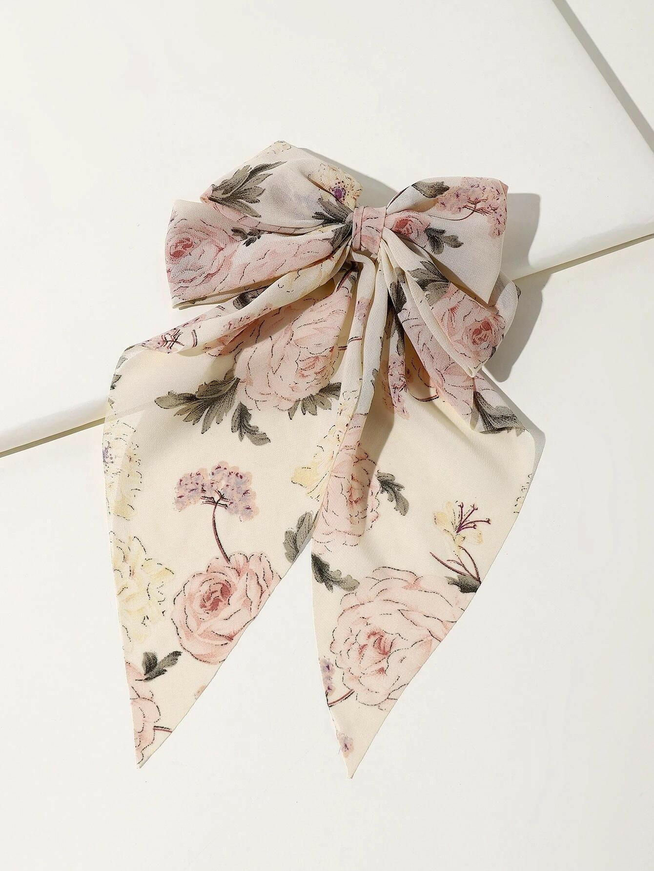 Hair clip with a bow and flower print decor, blending playful charm with floral motifs for a delightful accessory.